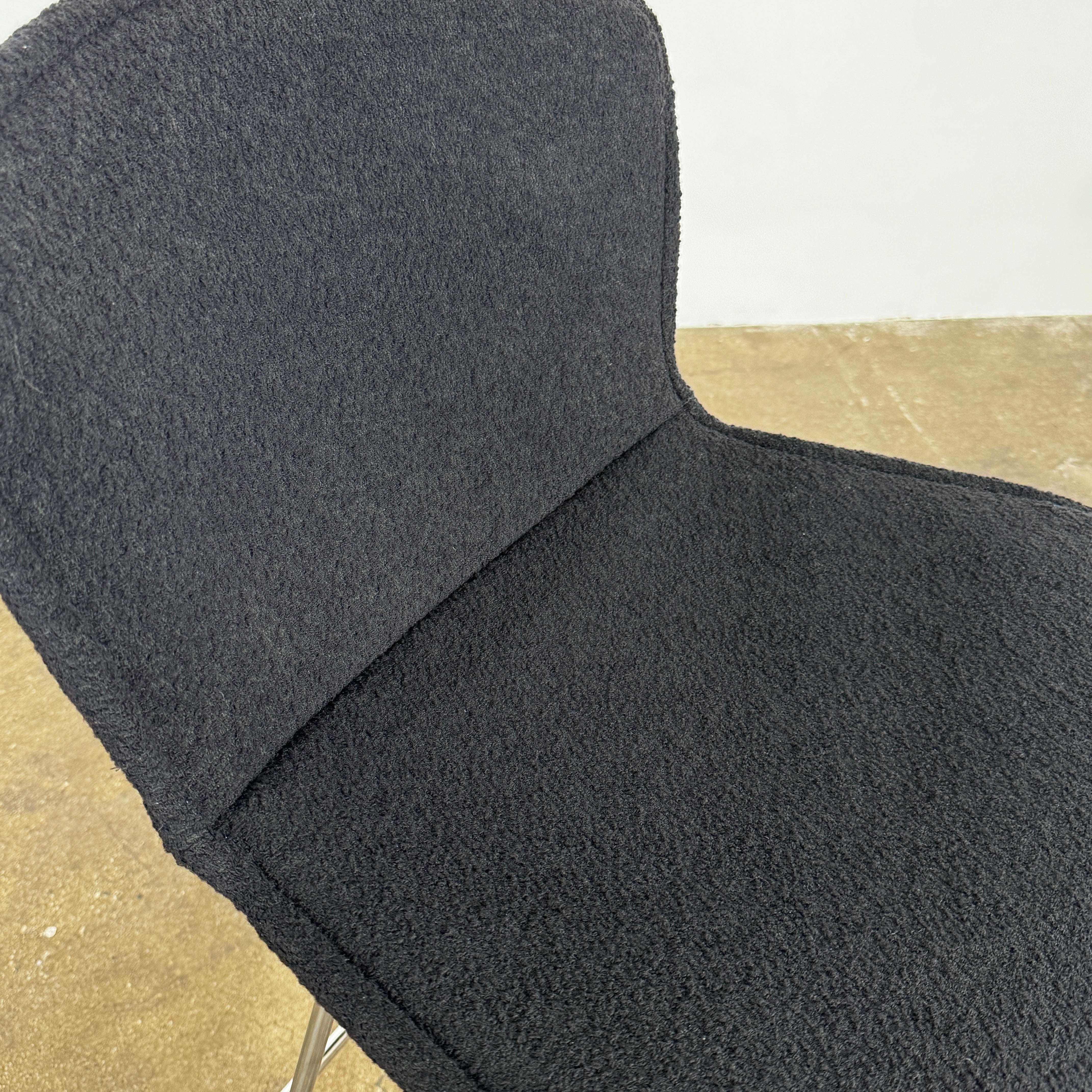 Close-up of a Knoll Bertoia Counter Stool from a set of 4, featuring a black cushion and textured black fabric over the backrest, placed on a polished concrete floor.