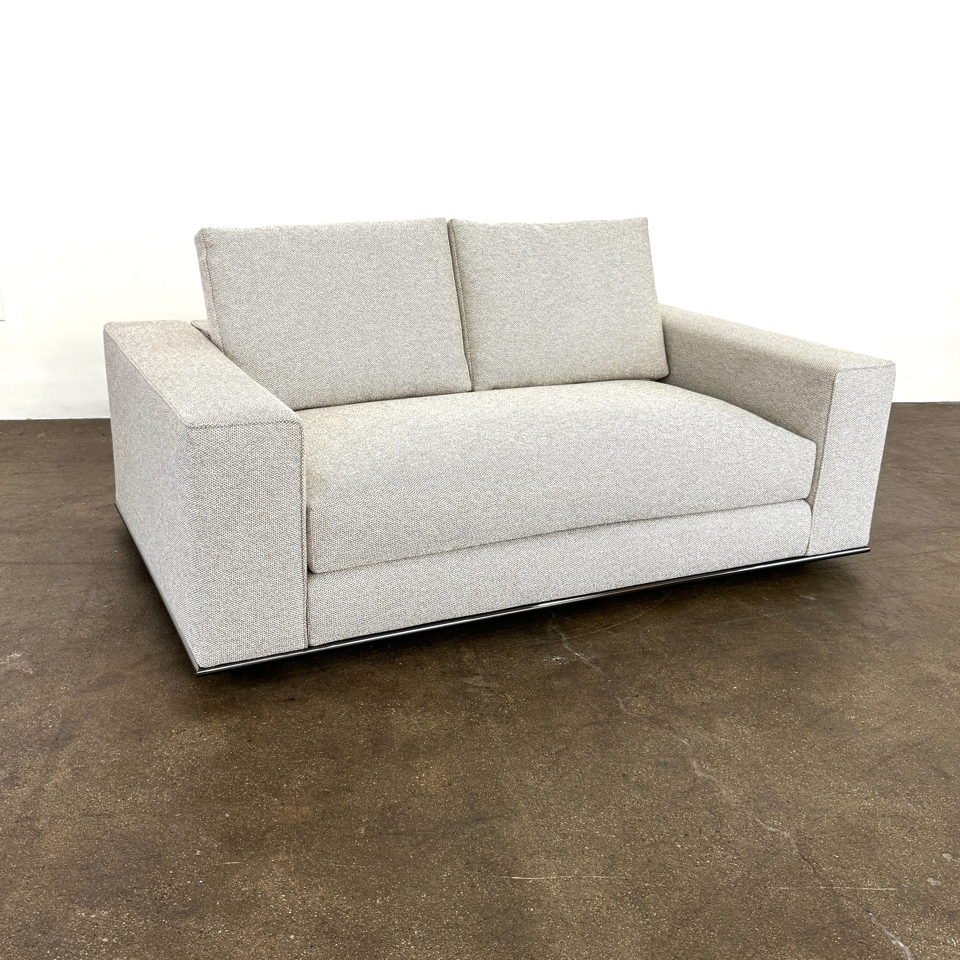 The Minotti Hamilton Love Seat 71" by Minotti, in light gray with two seat and two backrest cushions, is shown against a plain white background.