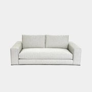 A close-up of knitted fabric featuring a Minotti label on black textile highlights the refined details of modern living furniture like the Minotti Hamilton Love Seat 82".