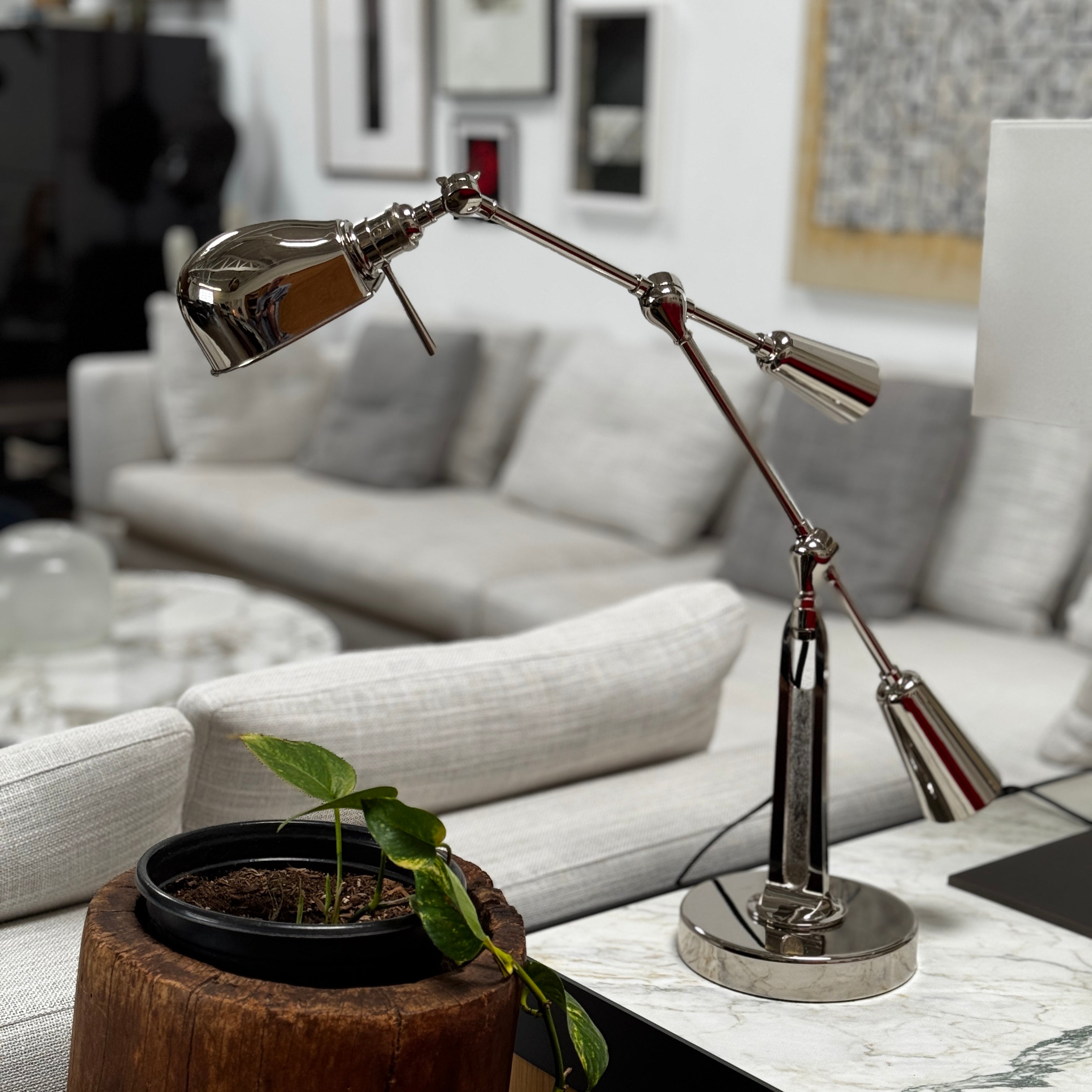 The Visual Comfort Ralph Lauren Signature Equilibrium table lamp by Visual Comfort Signature features a metallic, multi-jointed adjustable design with a round base, perfect for task lighting in modern interiors and shown on a white background.