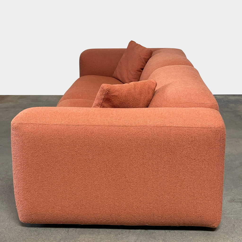 A comfortable, modern Design Within Reach Kelston Sofa in terracotta color with adjustable headrests isolated on a white background.