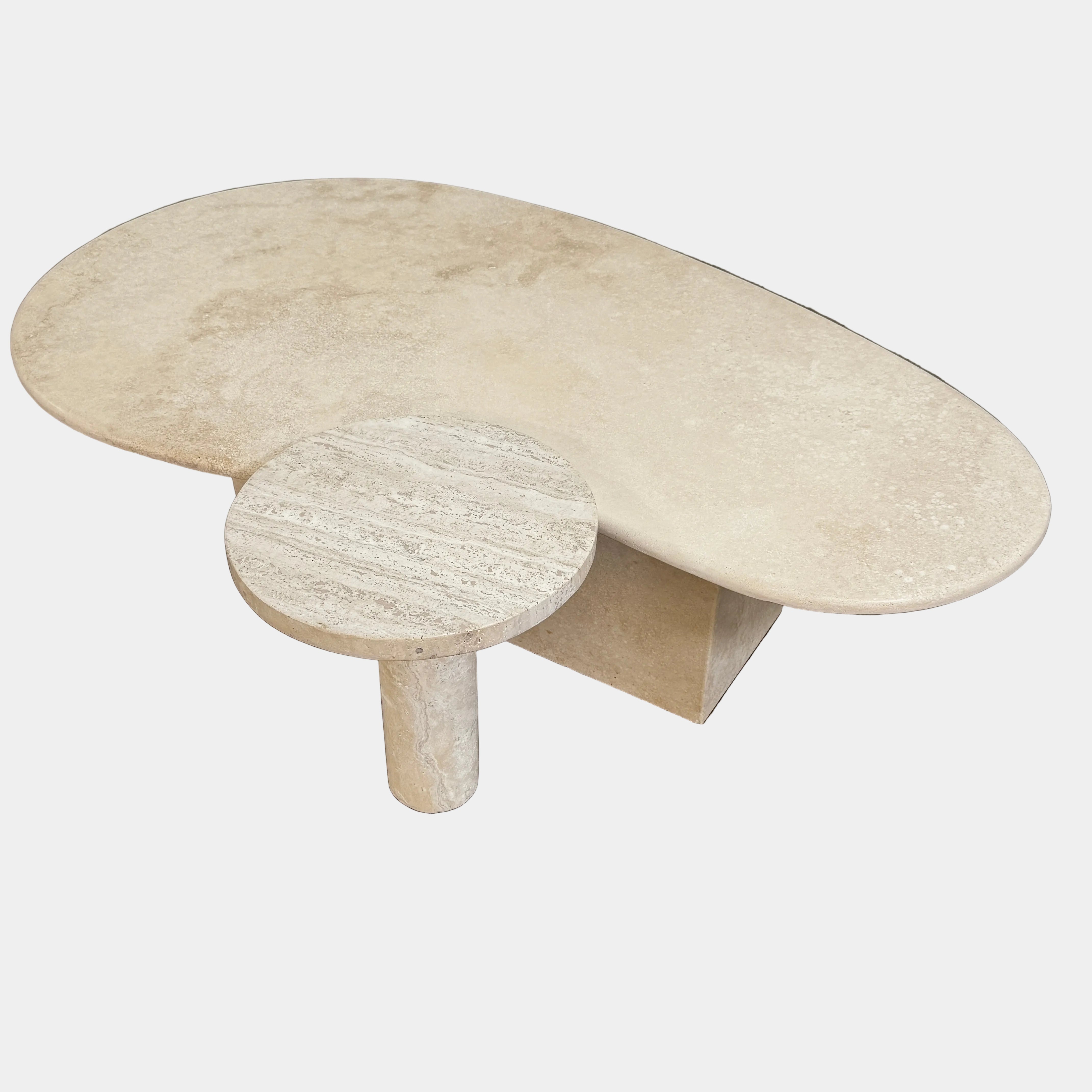 The Custom Travertine Coffee Table Set by Custom features two beige stone surfaces—one oval, one round—supported by solid travertine legs, offering sculptural elegance and modern style to any space.