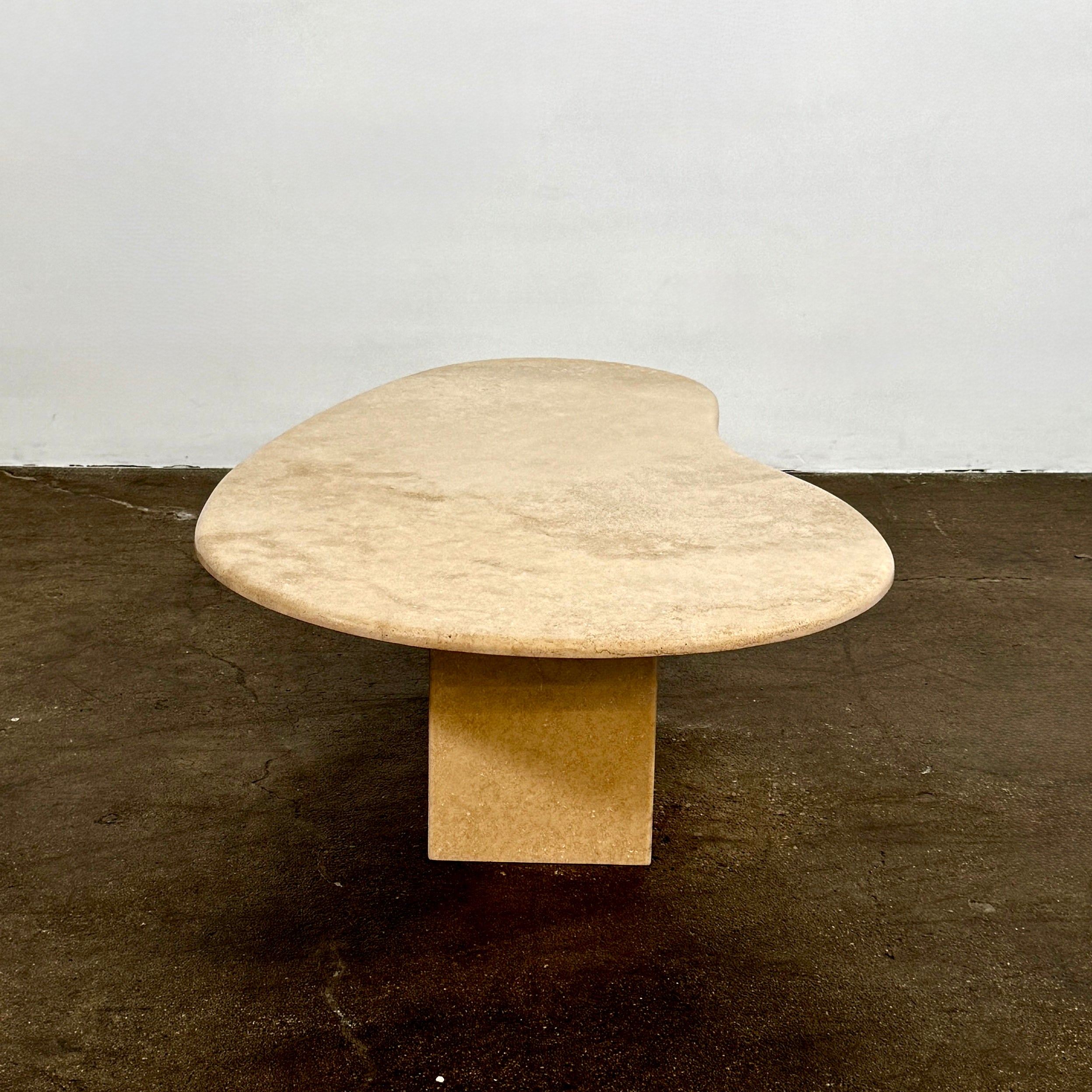 The Custom Travertine Coffee Table Set by Custom features two beige stone surfaces—one oval, one round—supported by solid travertine legs, offering sculptural elegance and modern style to any space.