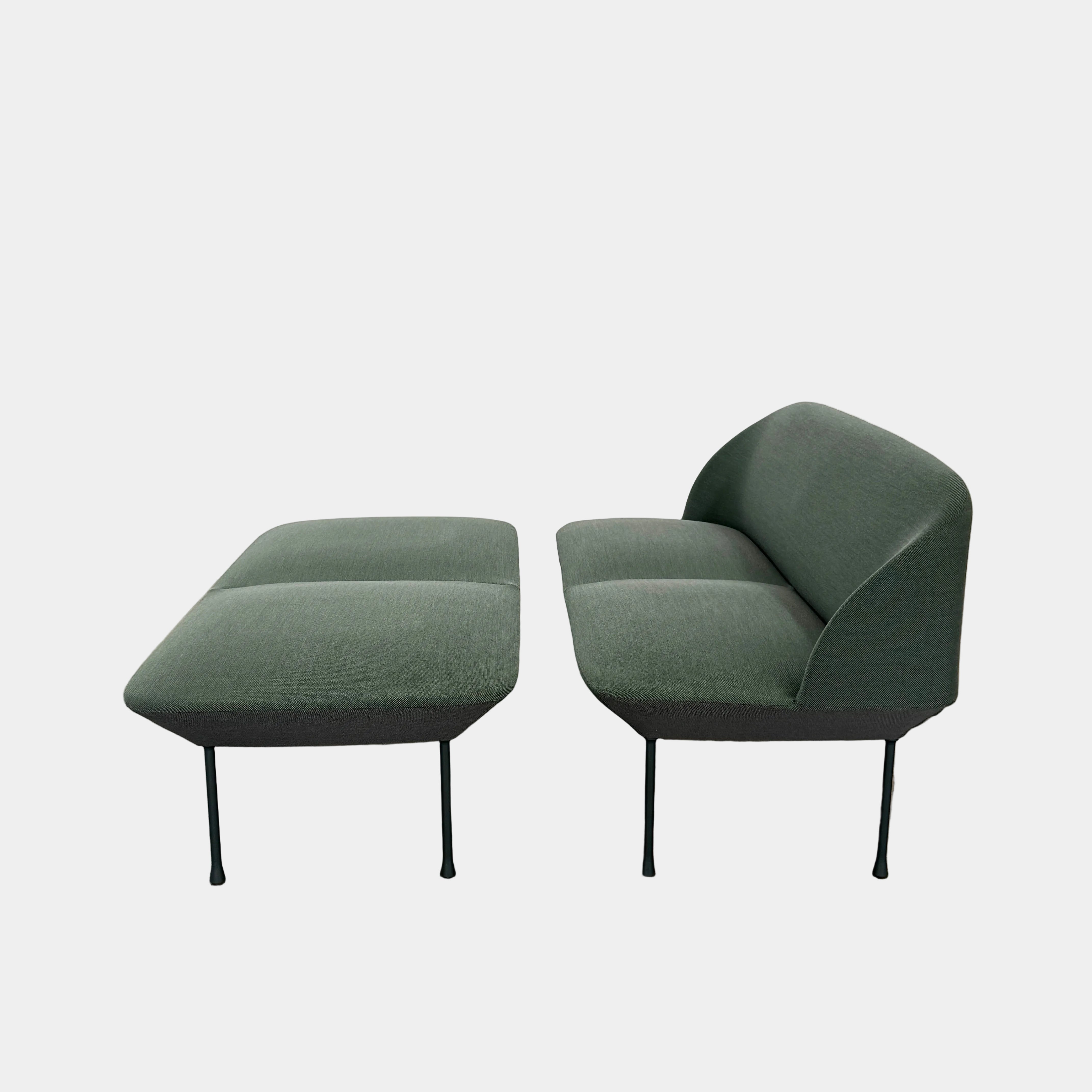The Muuto Oslo 2-seat sofa & bench by Muuto, featuring modern green upholstery and slim black legs inspired by Danish design, stands in a bright room with beige walls and sheer white curtains.