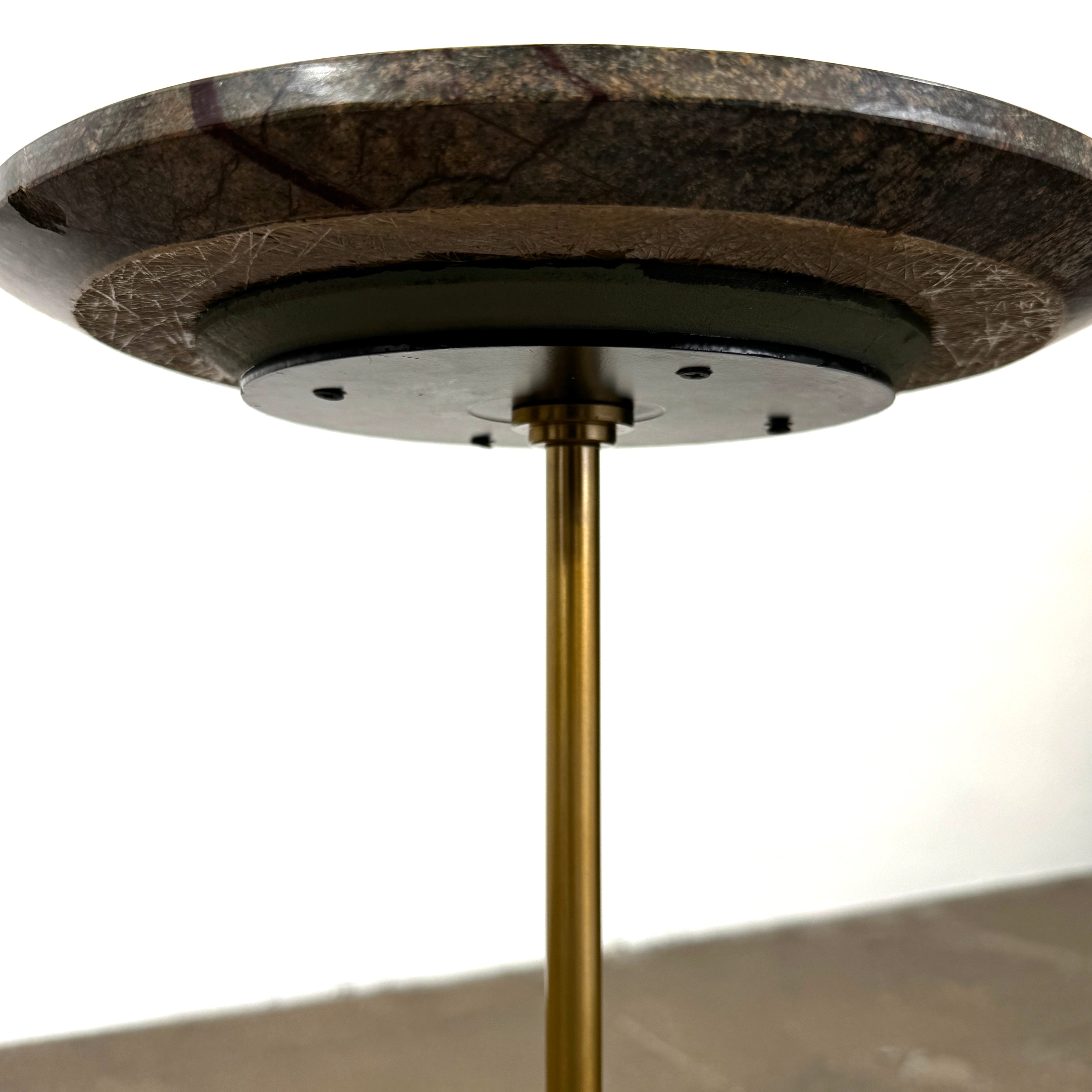 The Soho Home Fleet Side Table by Soho Home features a dark Verde Bosque marble top, slender antique brass stem, and a white cylindrical marble base, shown against a plain light background.