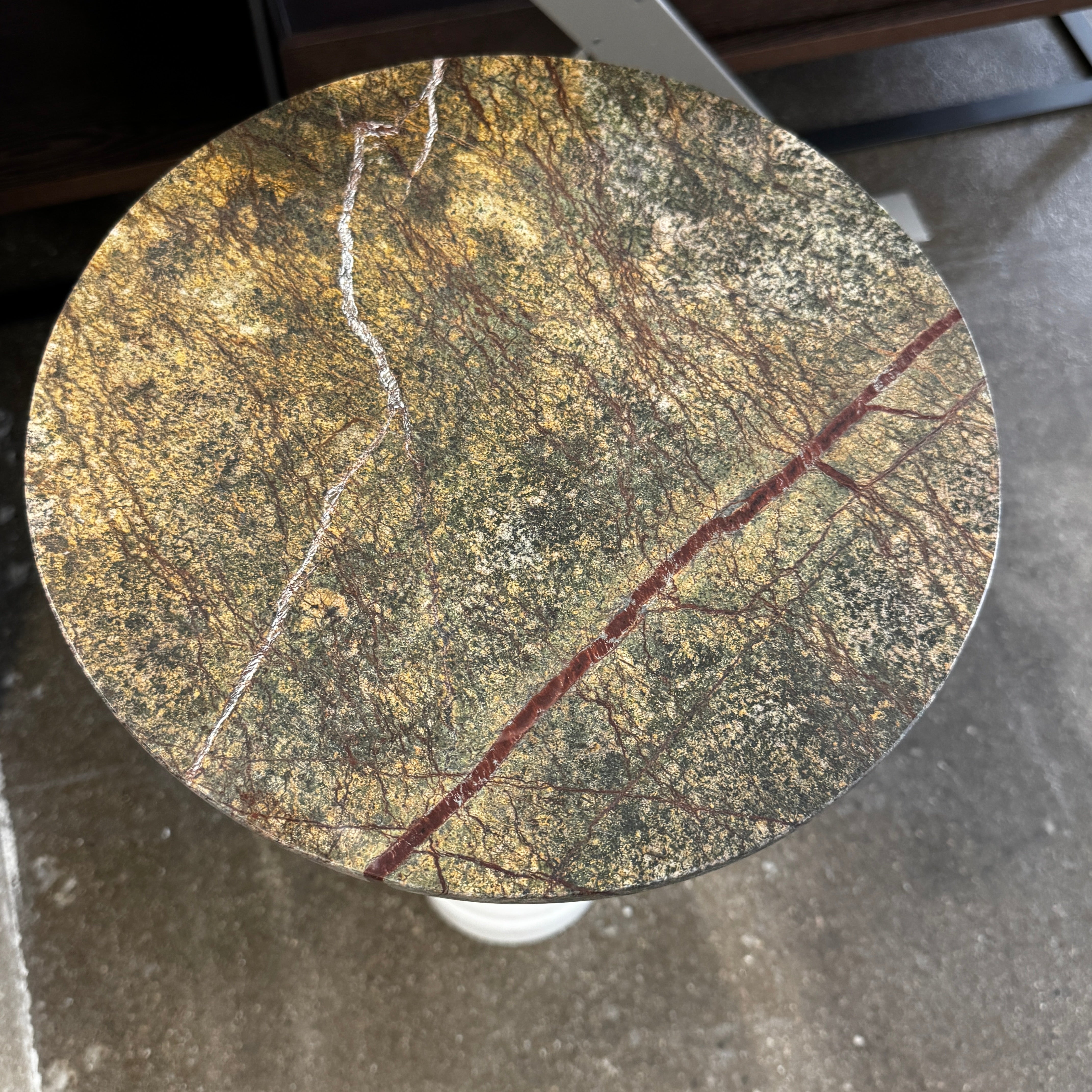 The Soho Home Fleet Side Table by Soho Home features a dark Verde Bosque marble top, slender antique brass stem, and a white cylindrical marble base, shown against a plain light background.