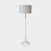 A modern Flos Spun Floor Light with a spun aluminum frame and a white base and shade.
