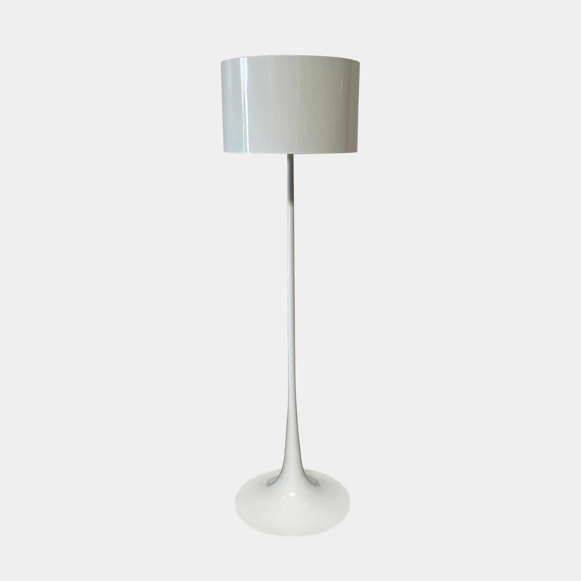 A modern Flos Spun Floor Light with a spun aluminum frame and a white base and shade.