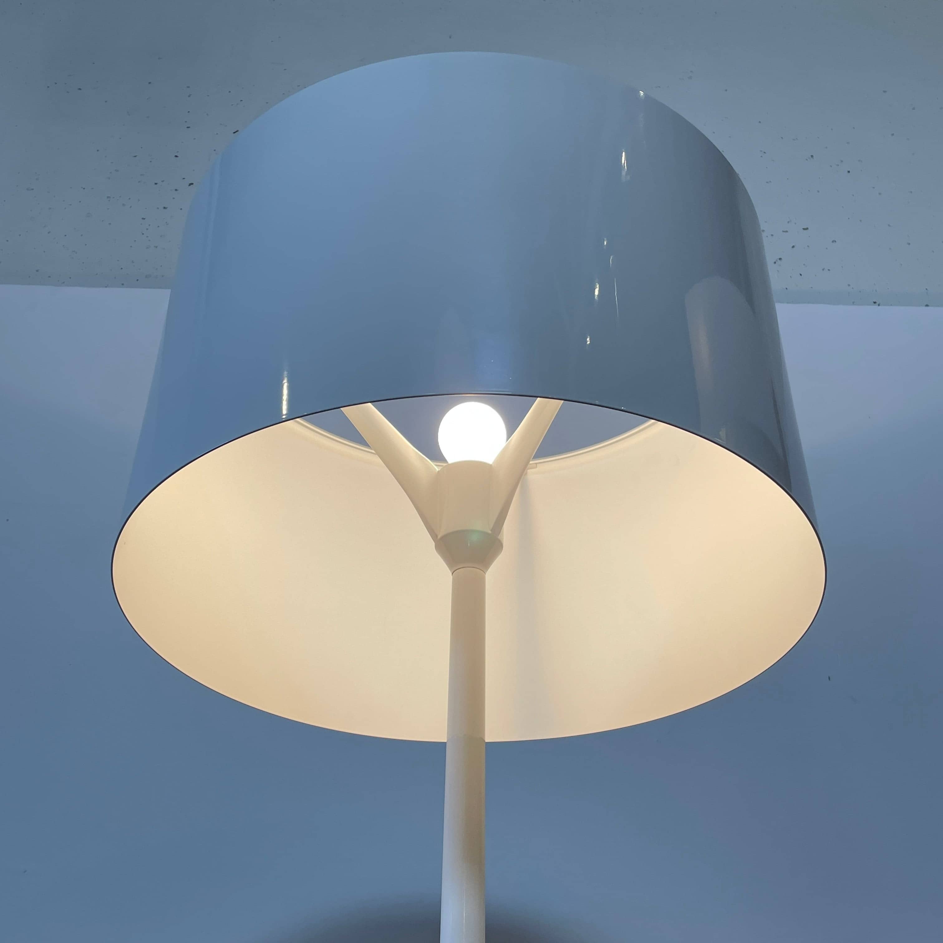 A modern Flos Spun Floor Light with a spun aluminum frame and a white base and shade.