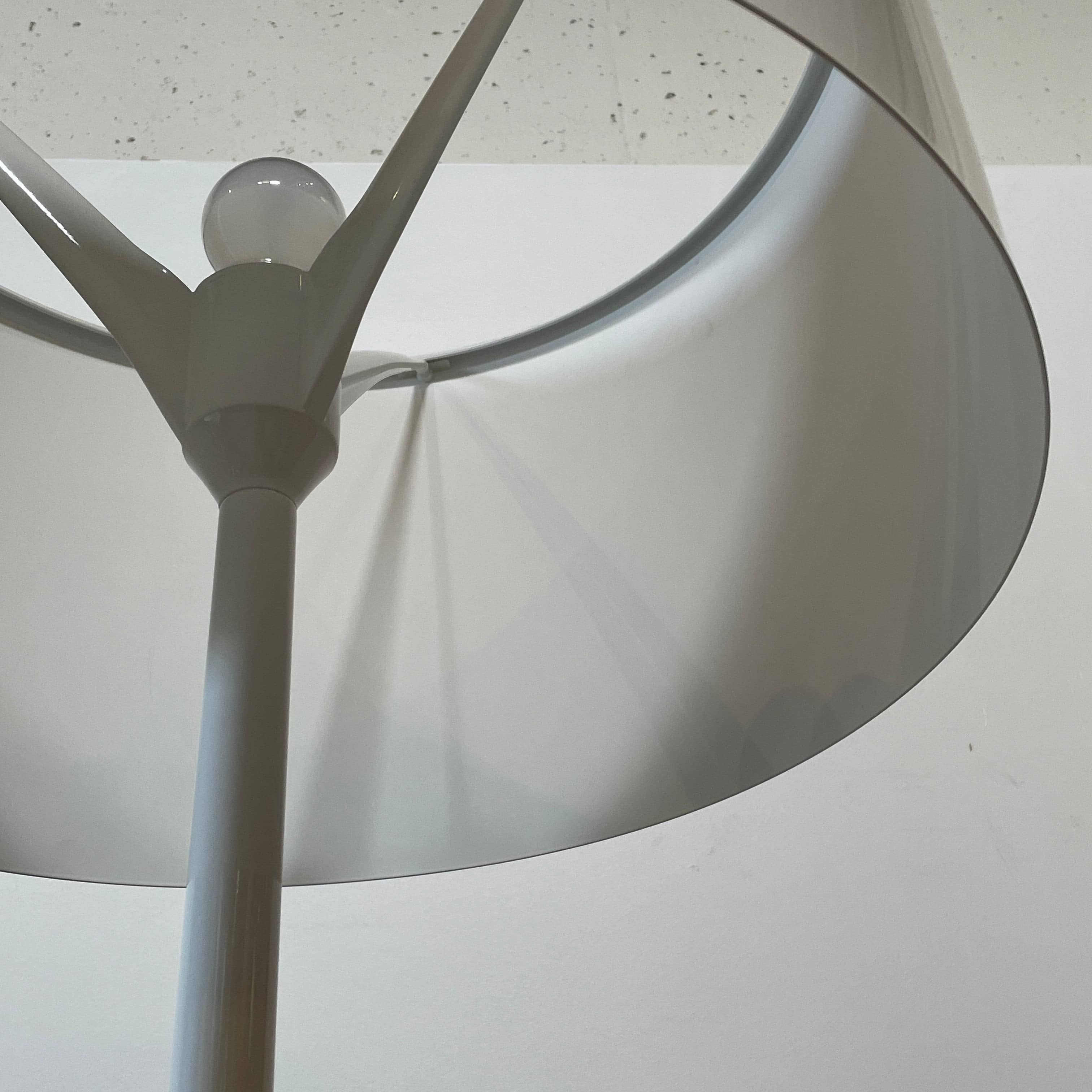 A modern Flos Spun Floor Light with a spun aluminum frame and a white base and shade.
