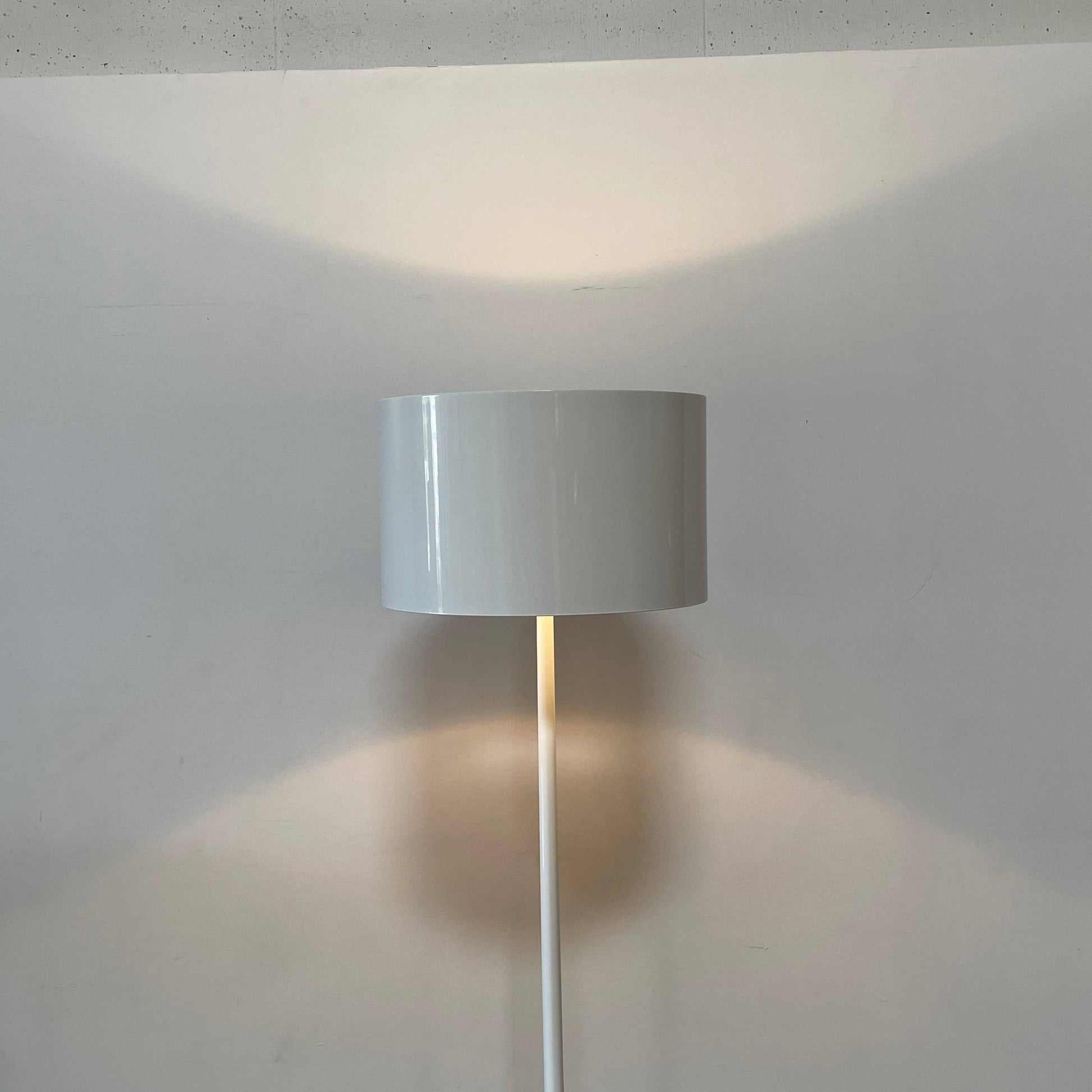 A modern Flos Spun Floor Light with a spun aluminum frame and a white base and shade.