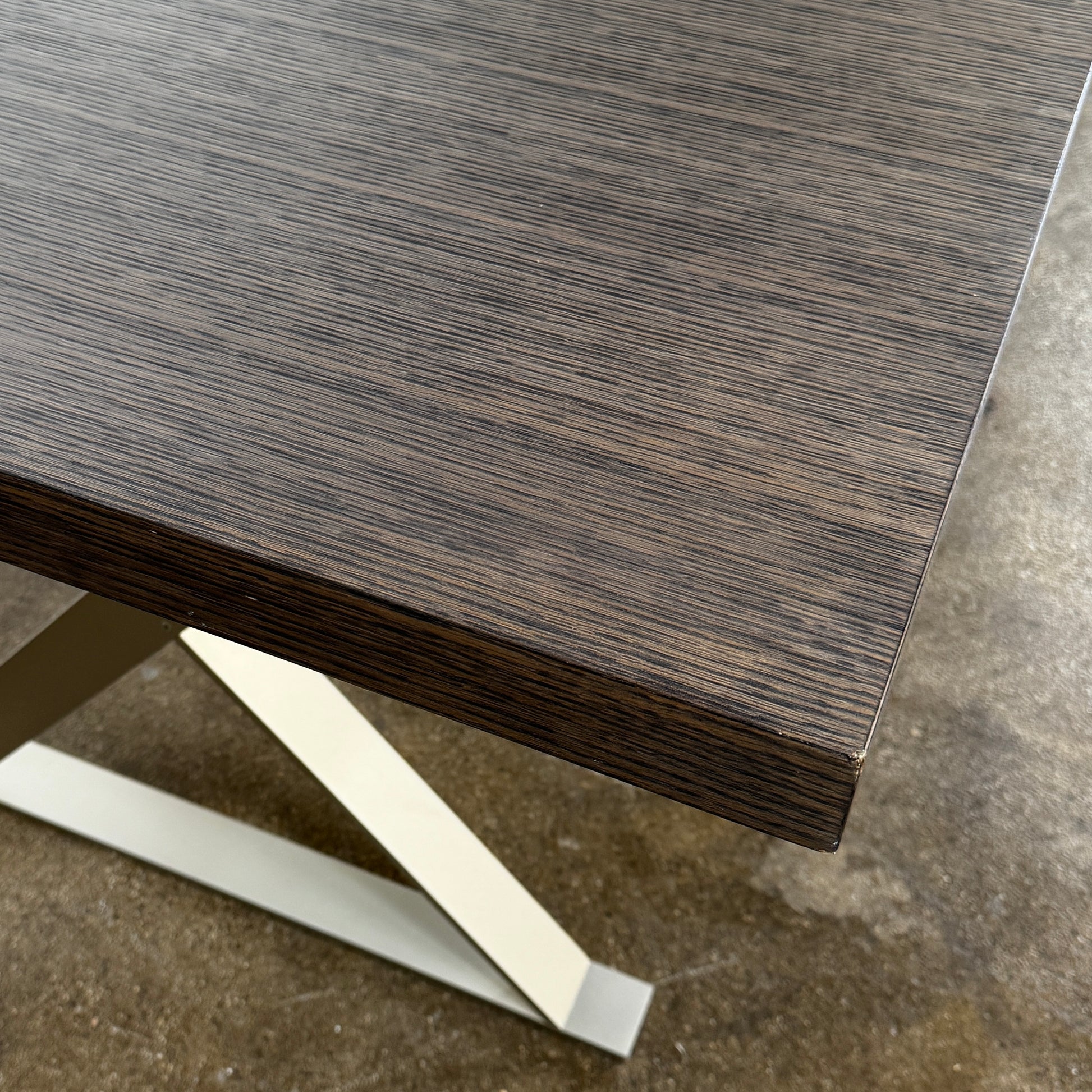 The Maxalto Max Table Grey Oak by Maxalto features a grey oak wooden top, metal legs, and an angular modern design—ideal for enhancing any dining space. Displayed on a plain white background.