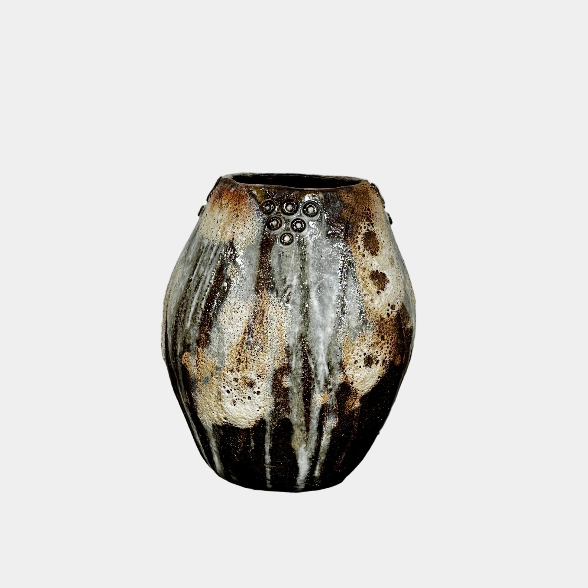 A hand-built dark clay Sofi Ceramics Ocean Vase, Tall by Artist, with irregular brown, black, and white glaze and small circular patterns near the top, set against a plain white background.