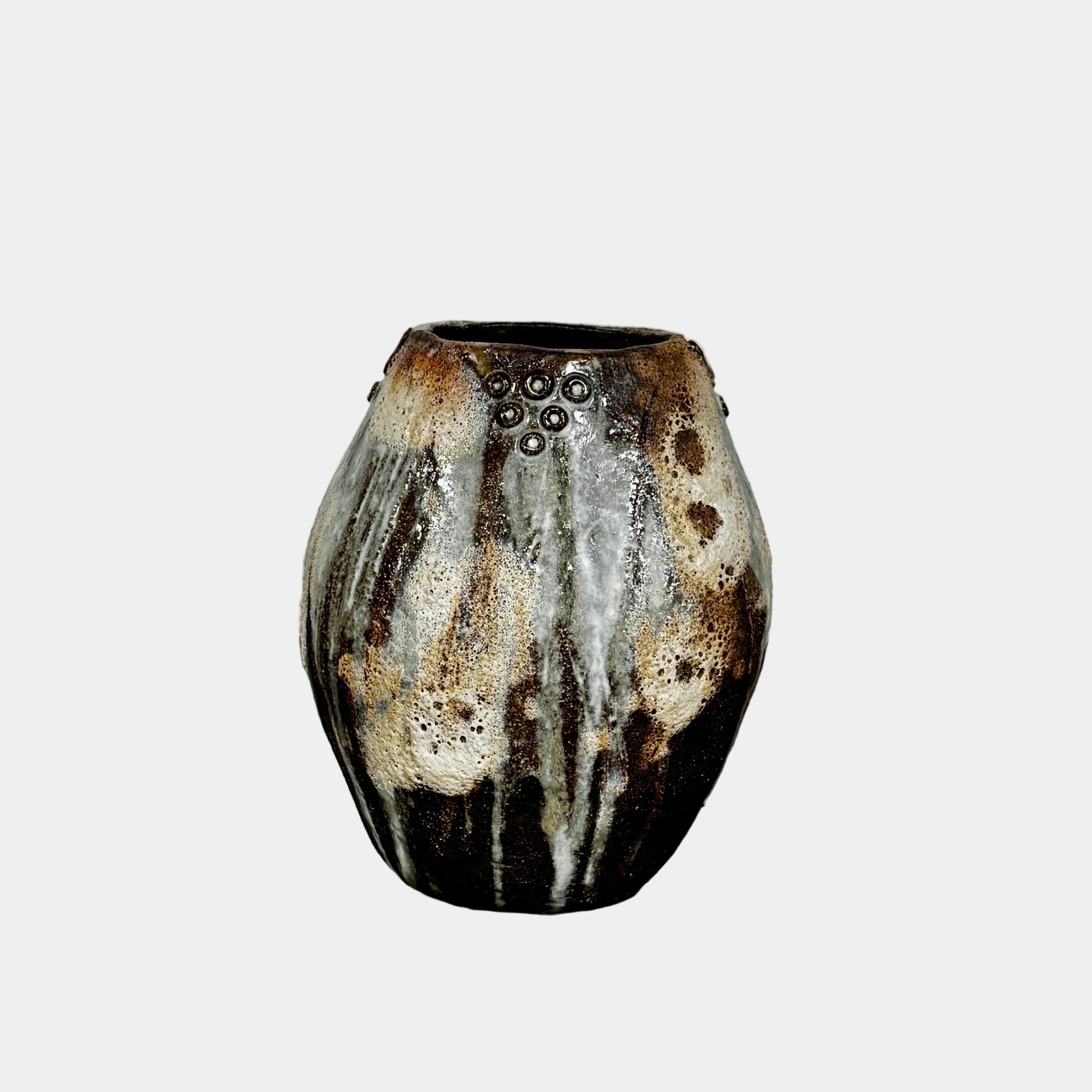 A hand-built dark clay Sofi Ceramics Ocean Vase, Tall by Artist, with irregular brown, black, and white glaze and small circular patterns near the top, set against a plain white background.