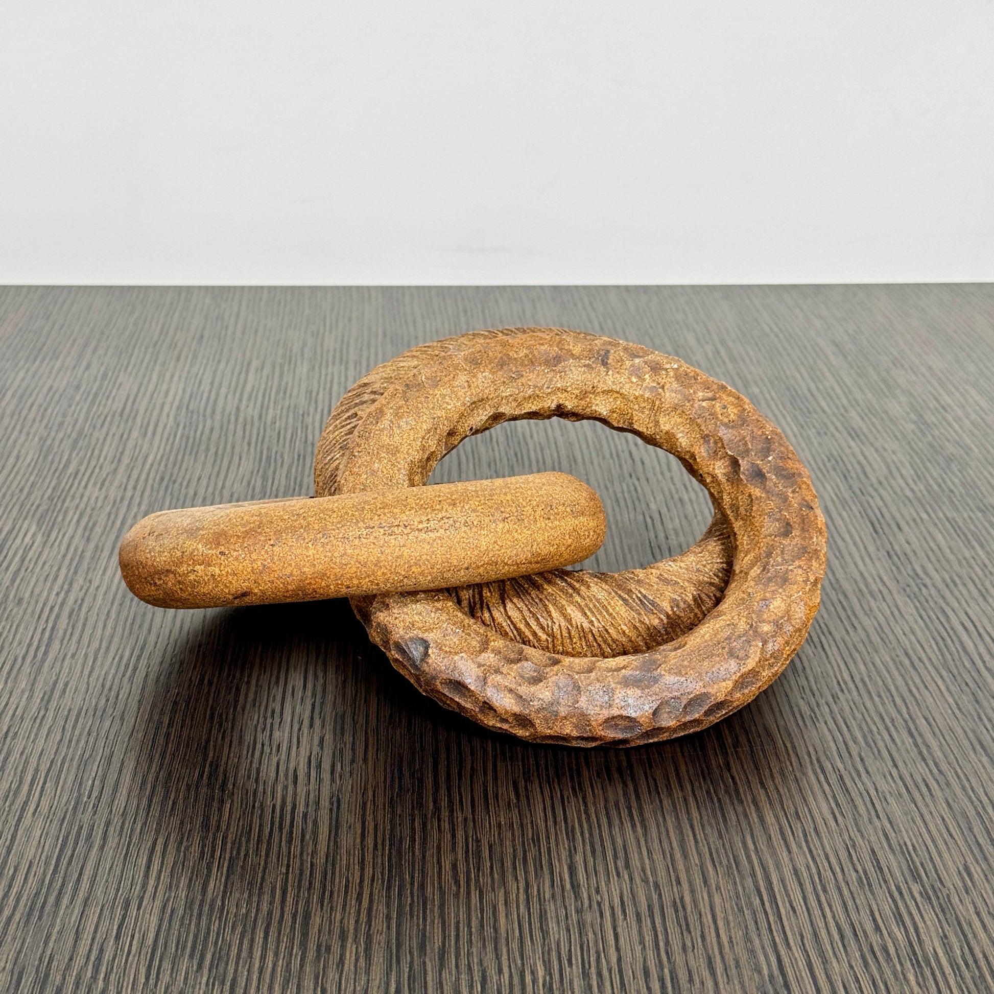 The Artist Sofi Ceramics Carved Rings feature two interlocking brown wooden rings with varied textures, evocative of ceramic artistry, shown on a plain white background.