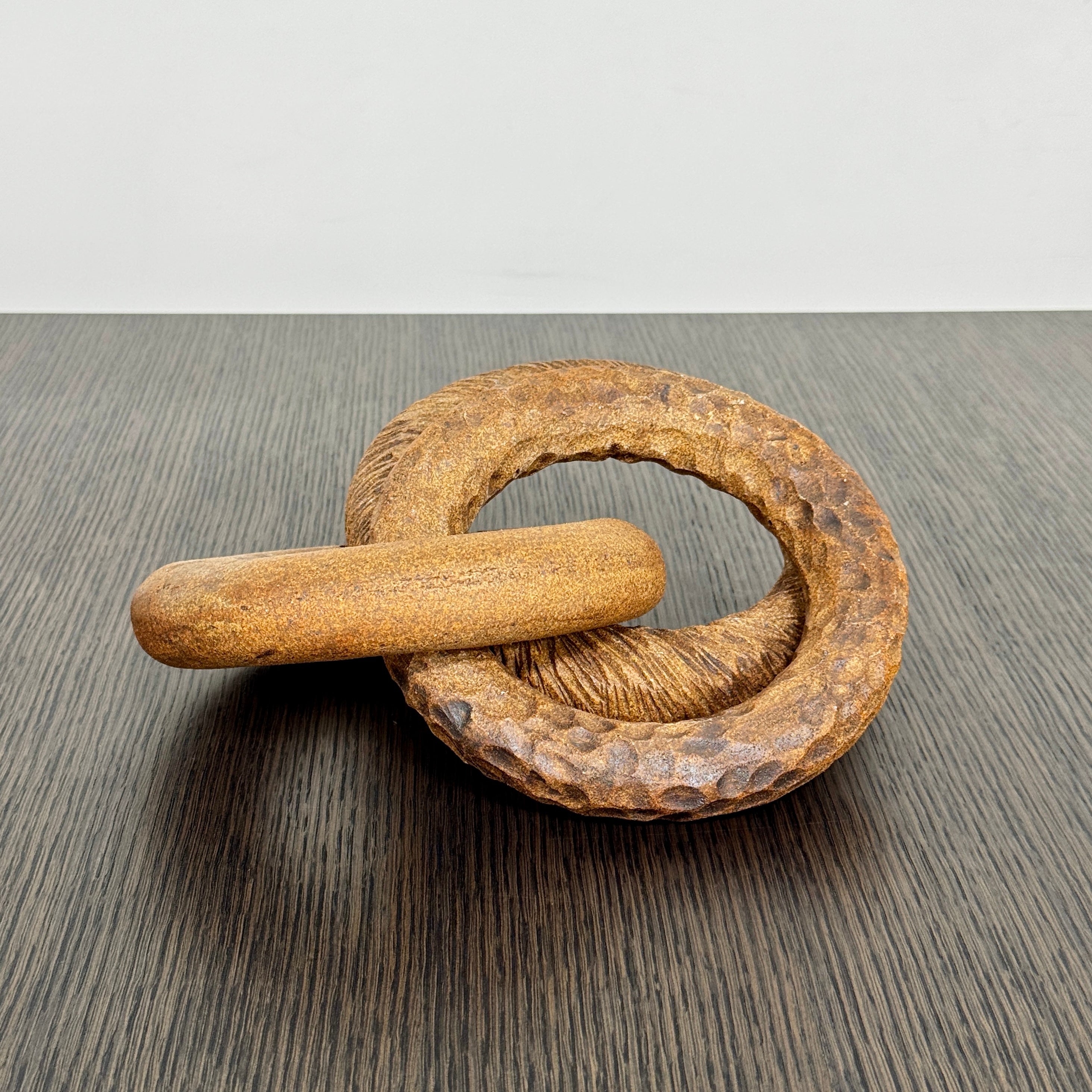 The Artist Sofi Ceramics Carved Rings feature two interlocking brown wooden rings with varied textures, evocative of ceramic artistry, shown on a plain white background.