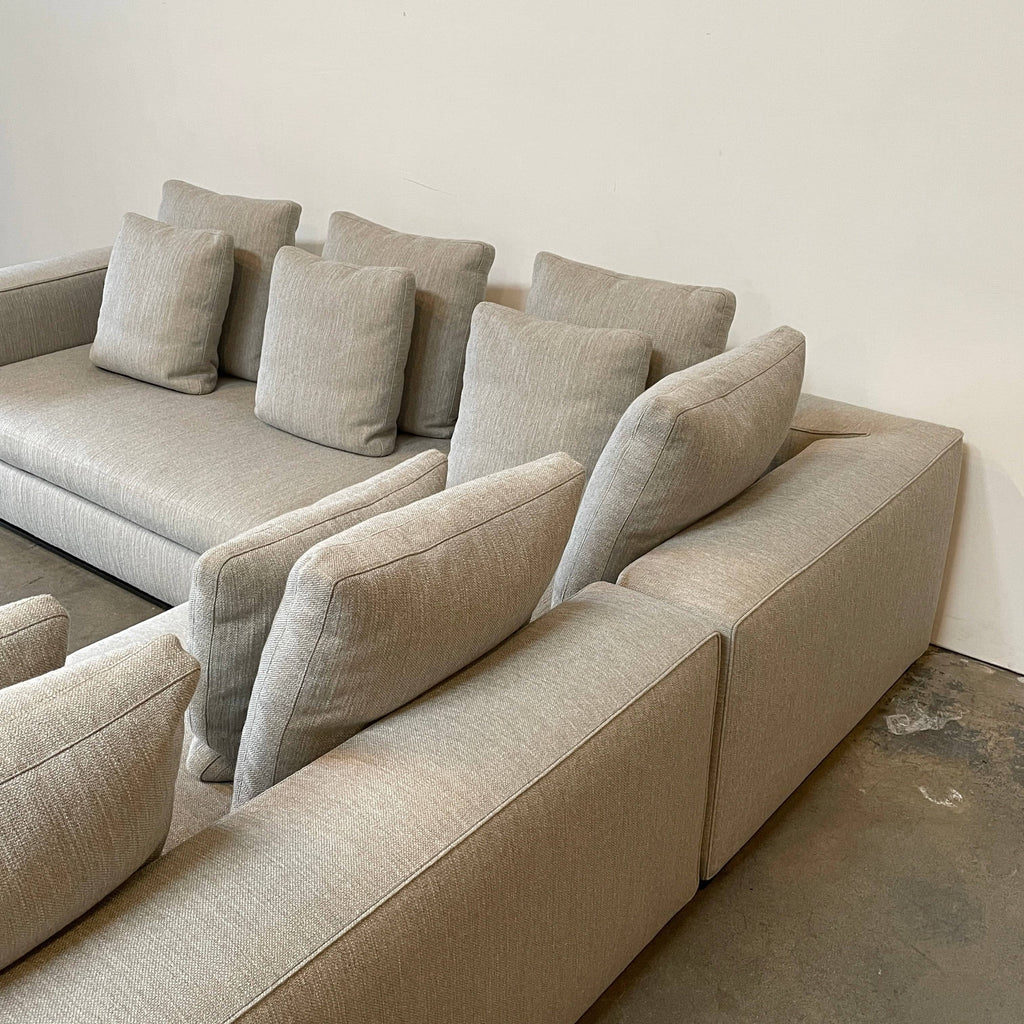 A Minotti Leonard Sectional sofa, an L-shaped with cushions, on a white background.