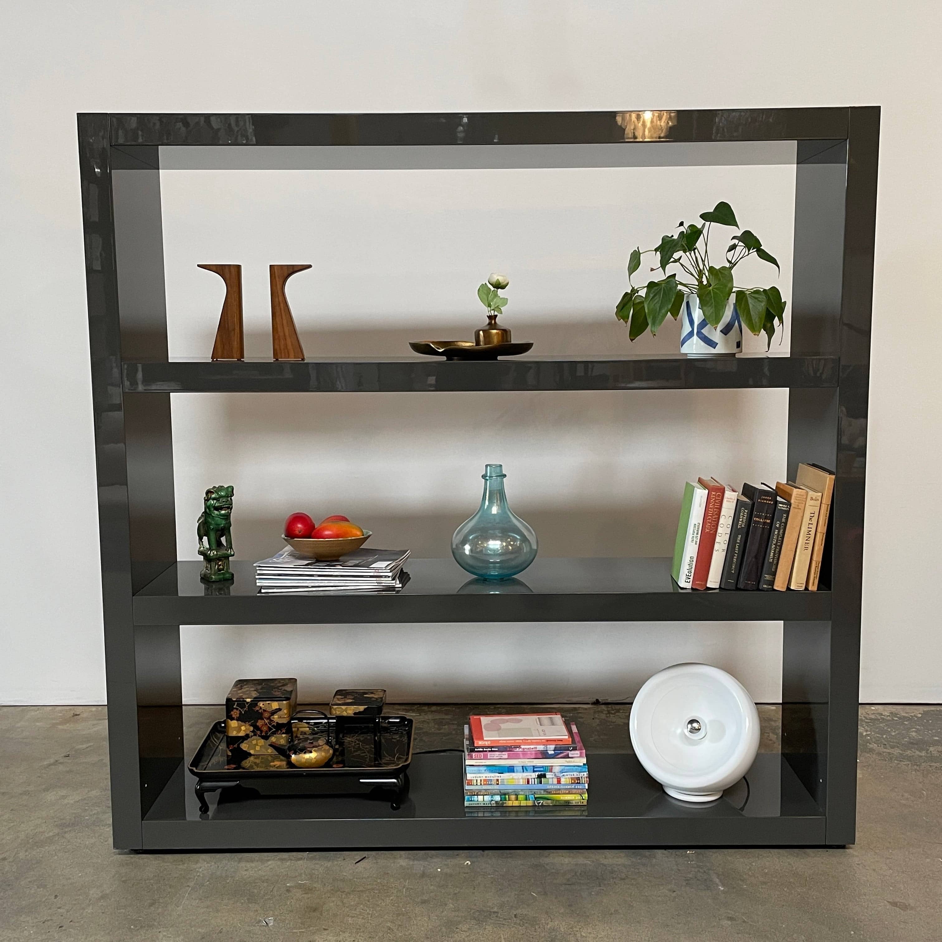 A black Minotti Johns Bookcase with three shelves on it.