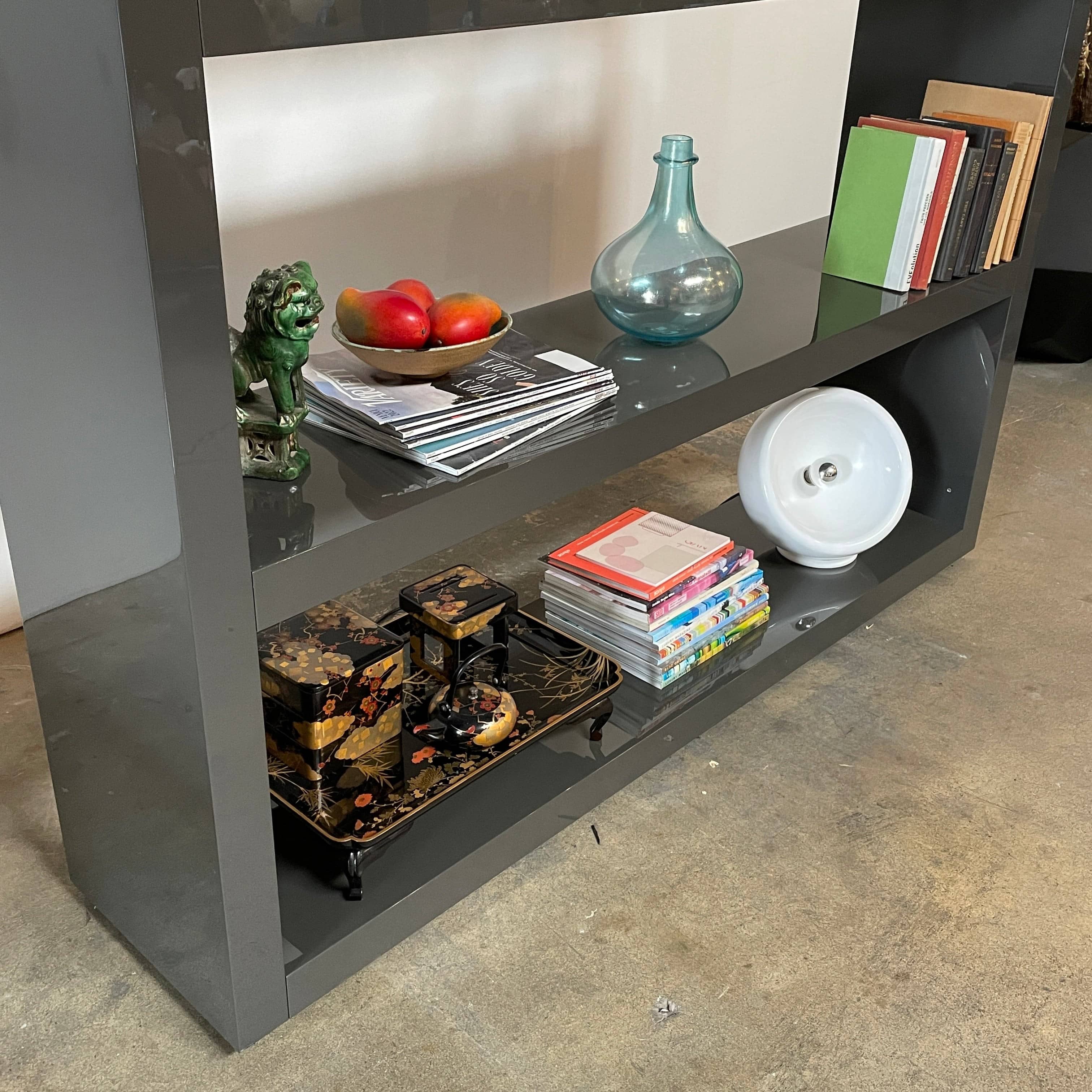 A black Minotti Johns Bookcase with three shelves on it.