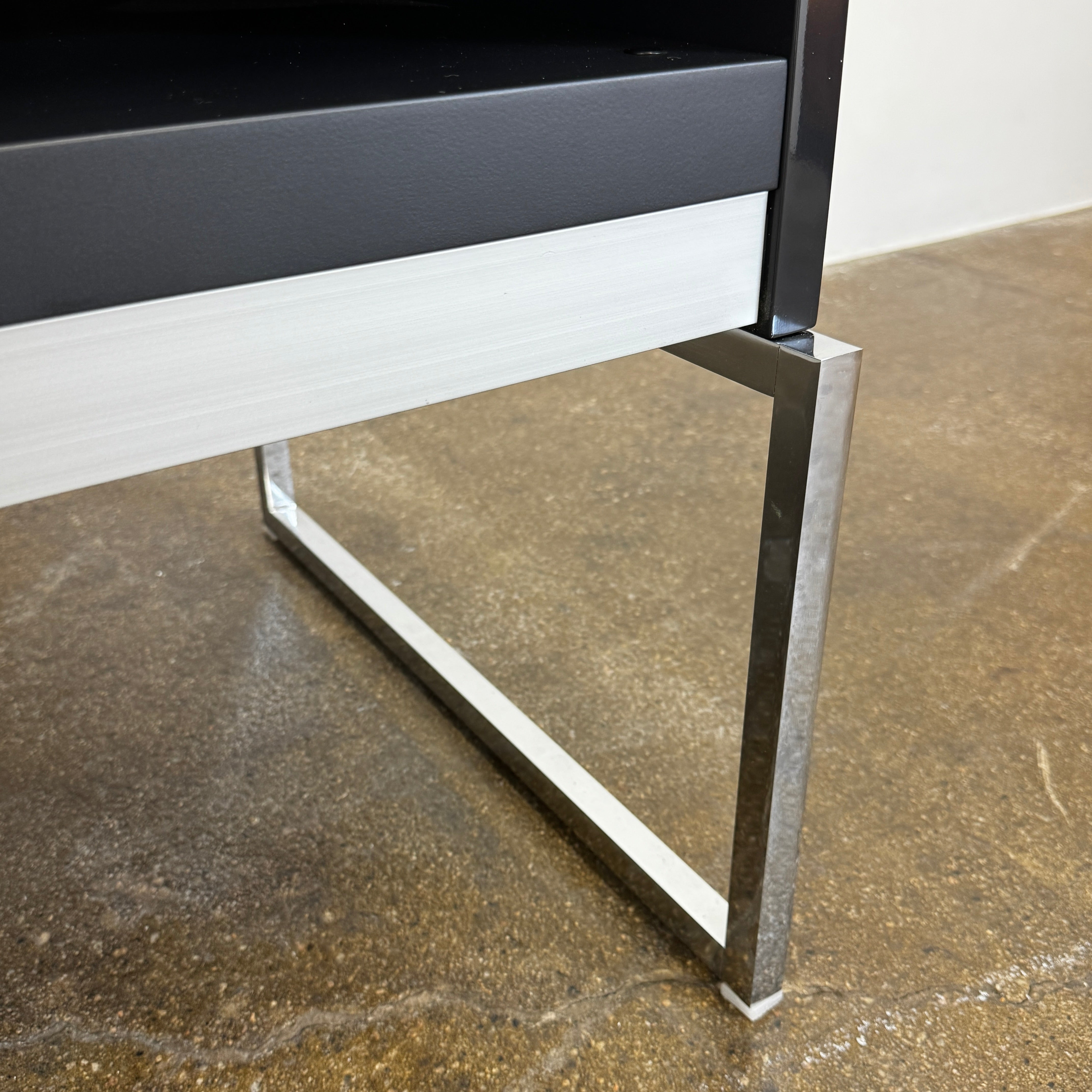 The B&B Italia Athos Console features a modern black rectangular design with a glossy finish and metal legs, showcased against a plain white background.