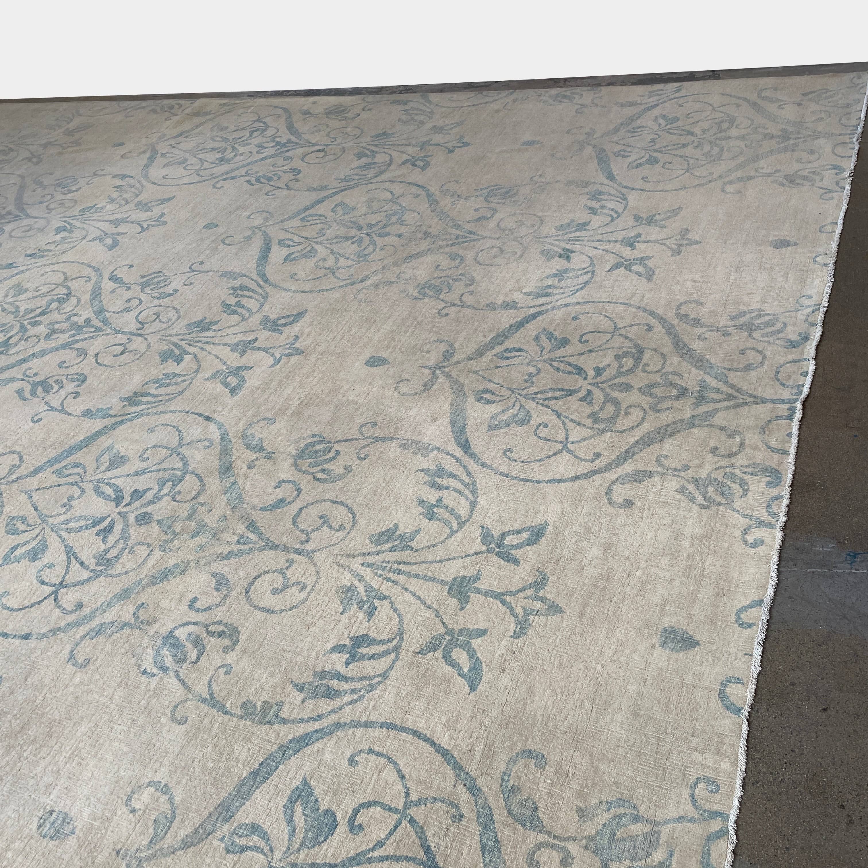 Close-up of a corner of an ornate, traditional Vintage rug with blue patterns on a beige background.