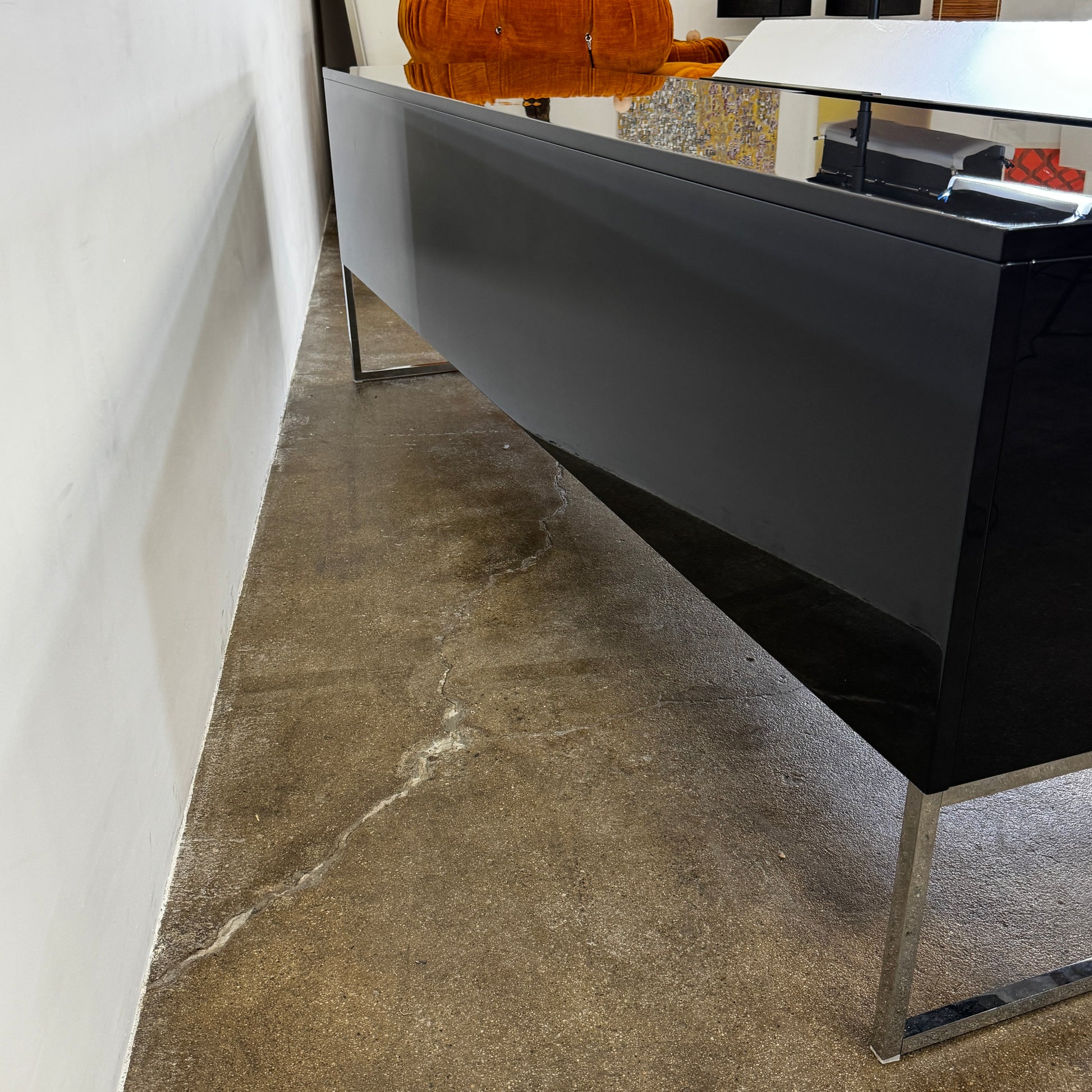 The B&B Italia Athos Console features a modern black rectangular design with a glossy finish and metal legs, showcased against a plain white background.