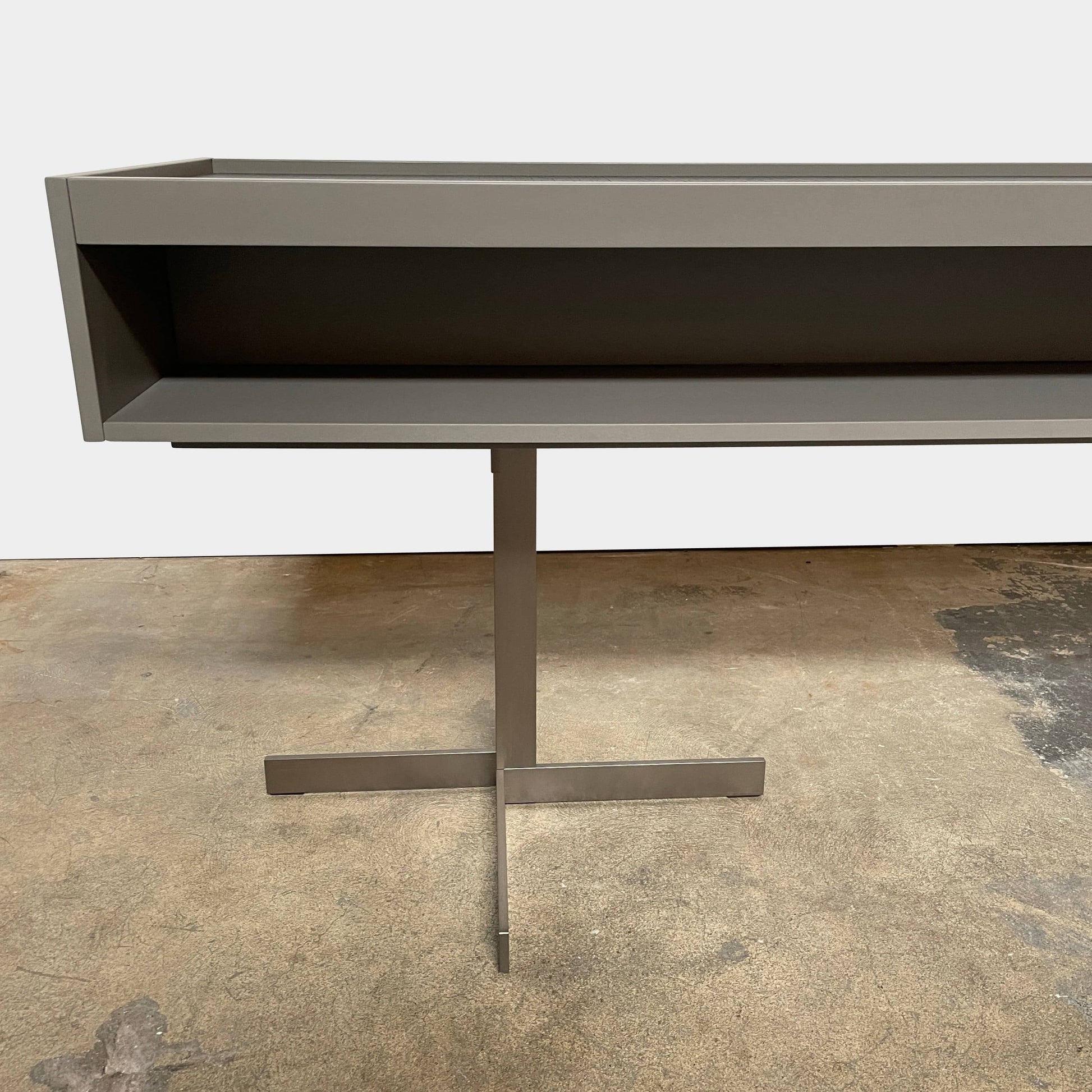 A Minotti Close Console with black legs and a glass top.