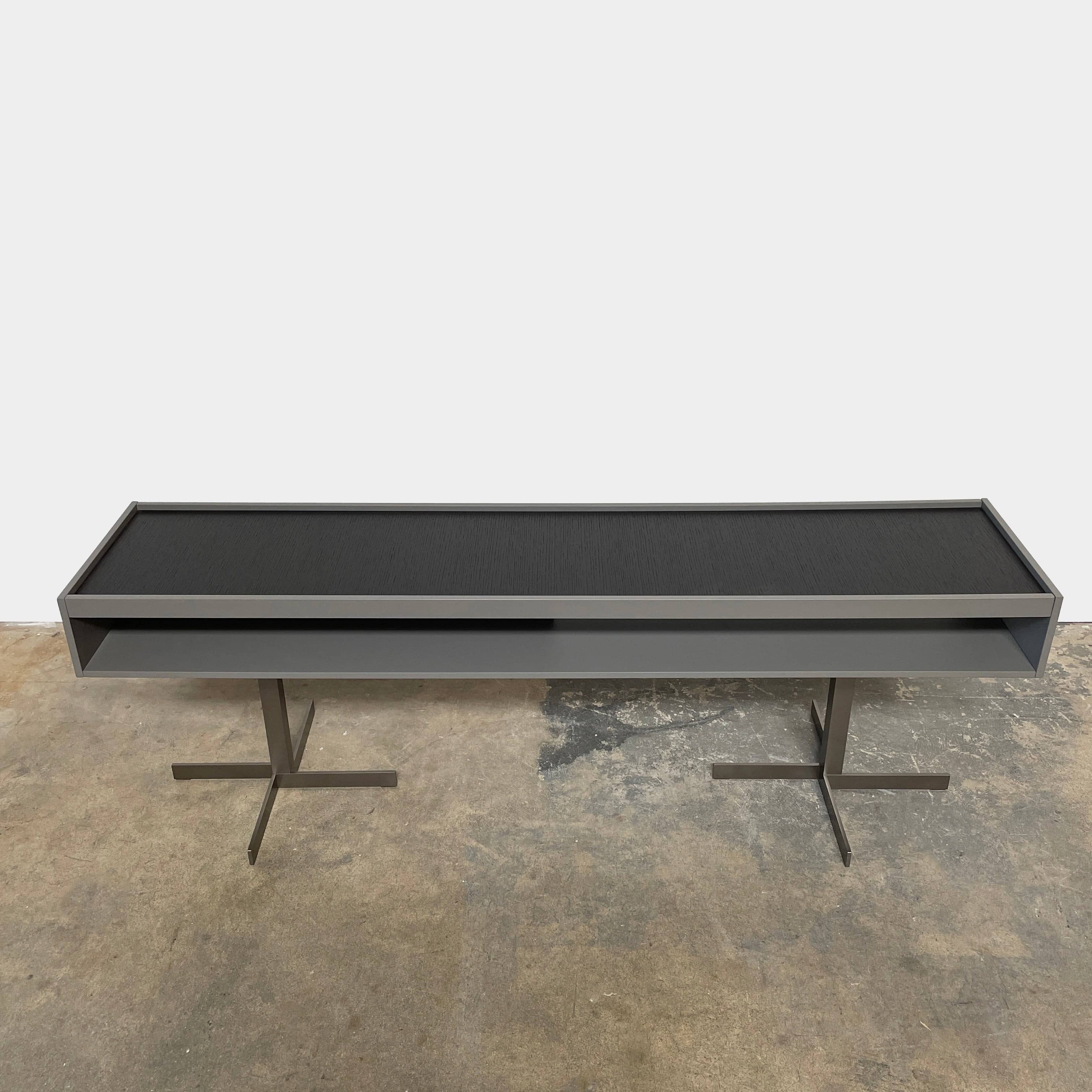 A Minotti Close Console with black legs and a glass top.