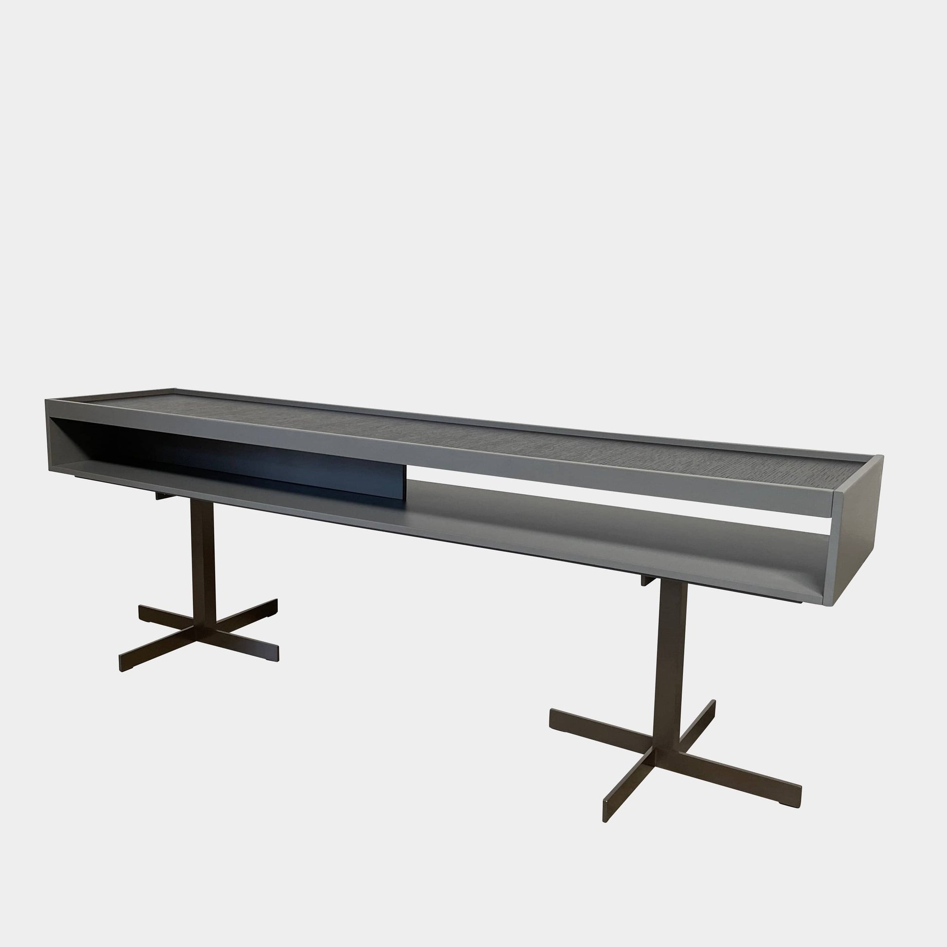 A Minotti Close Console with black legs and a glass top.