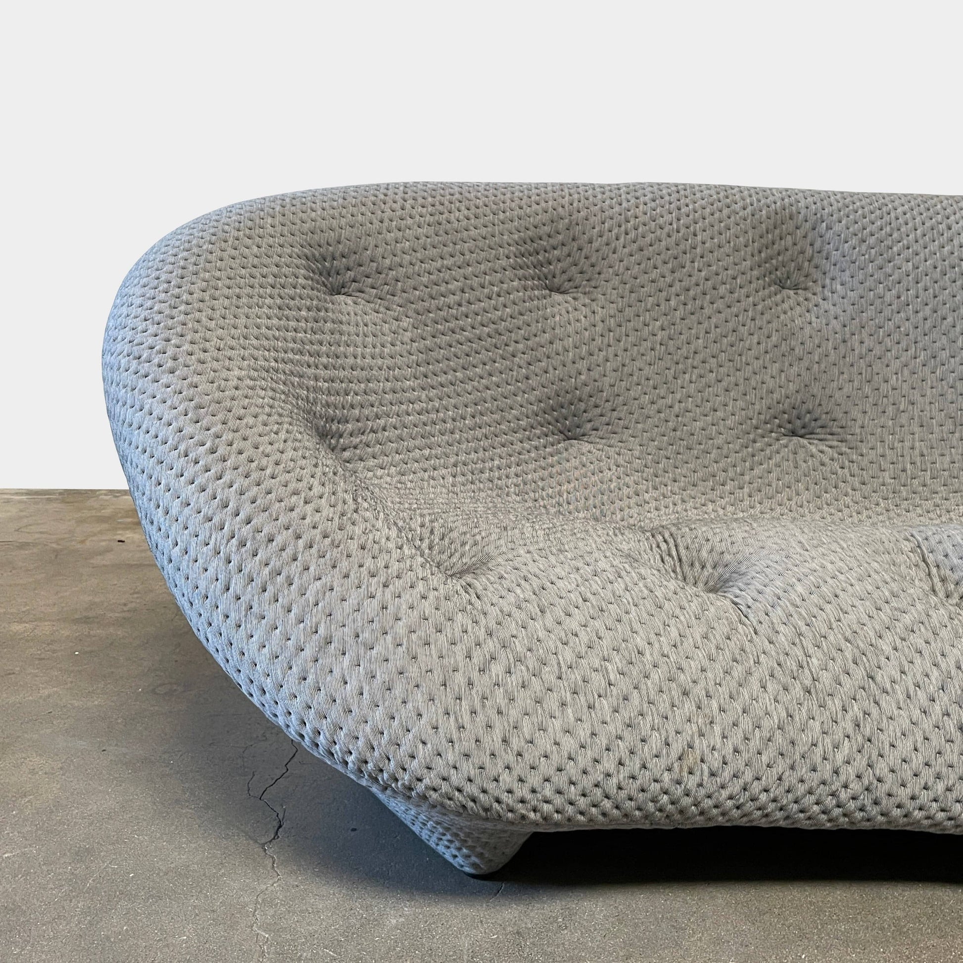 Modern tufted Ligne Roset Ploum sofa isolated against a white background.