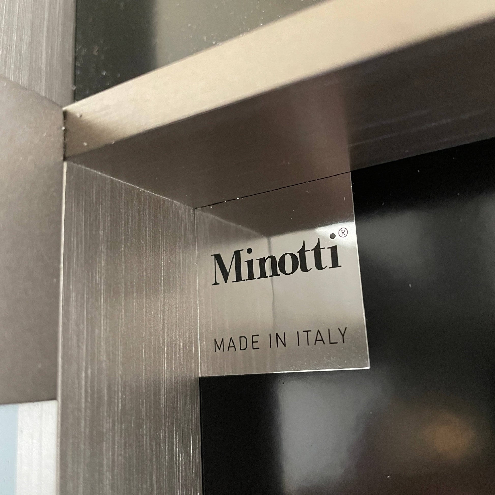 A Minotti Close Console with black legs and a glass top.