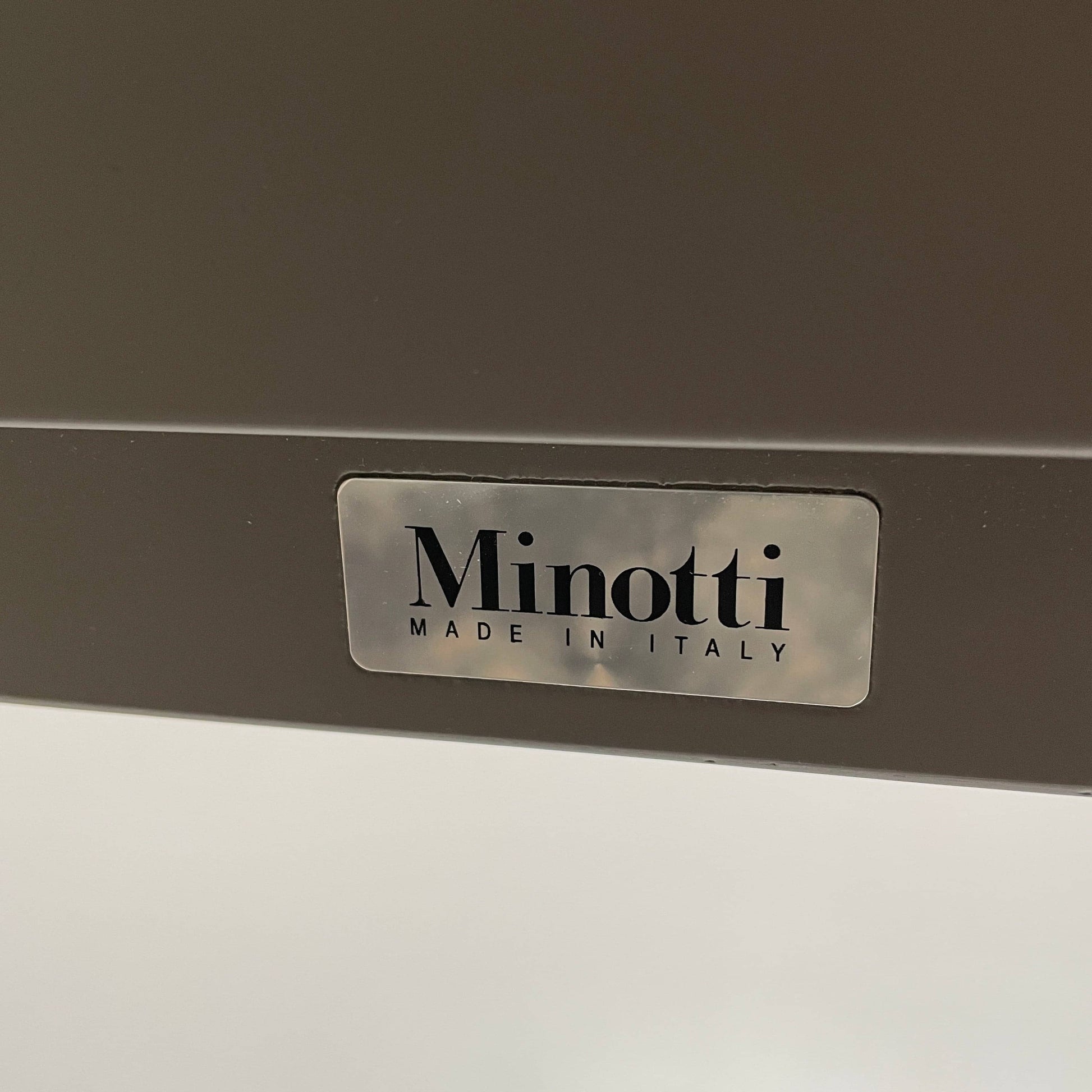 A Minotti Close Console with black legs and a glass top.