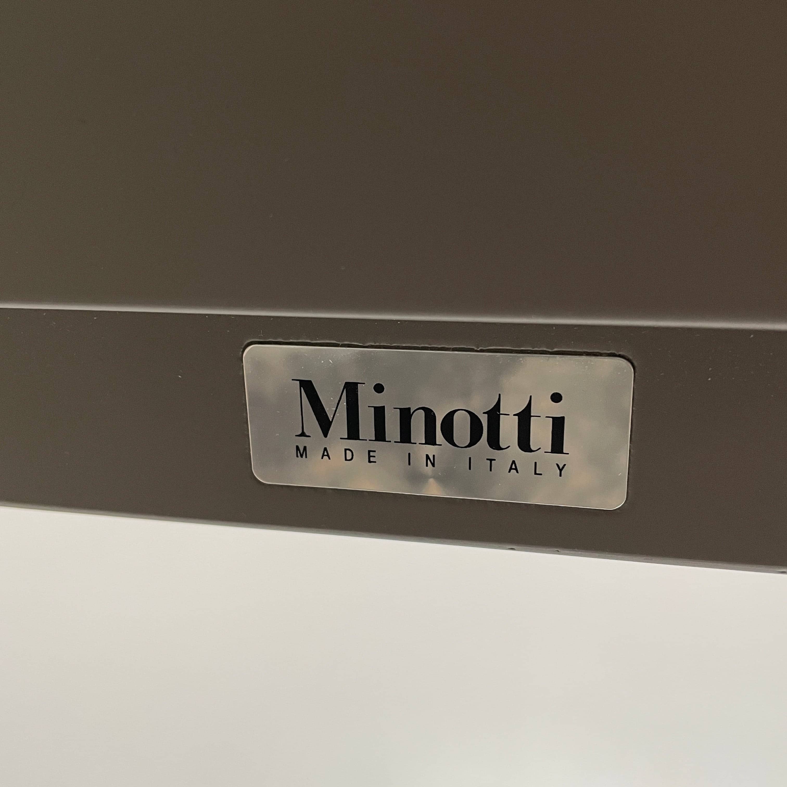 A Minotti Close Console with black legs and a glass top.