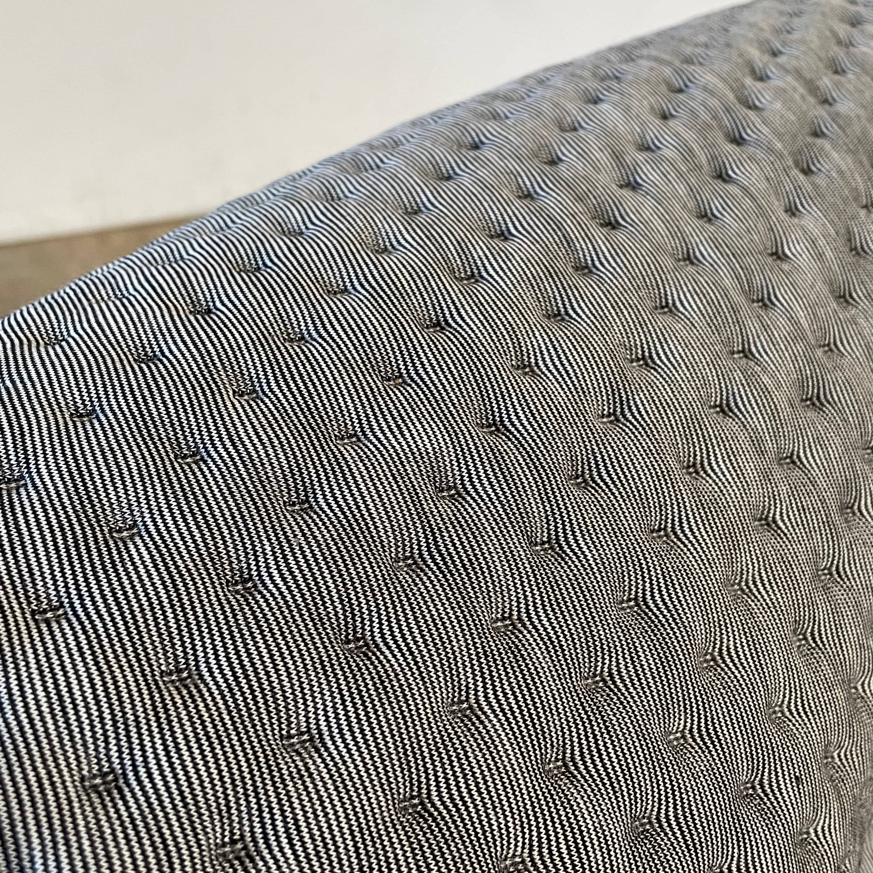 Modern tufted Ligne Roset Ploum sofa isolated against a white background.