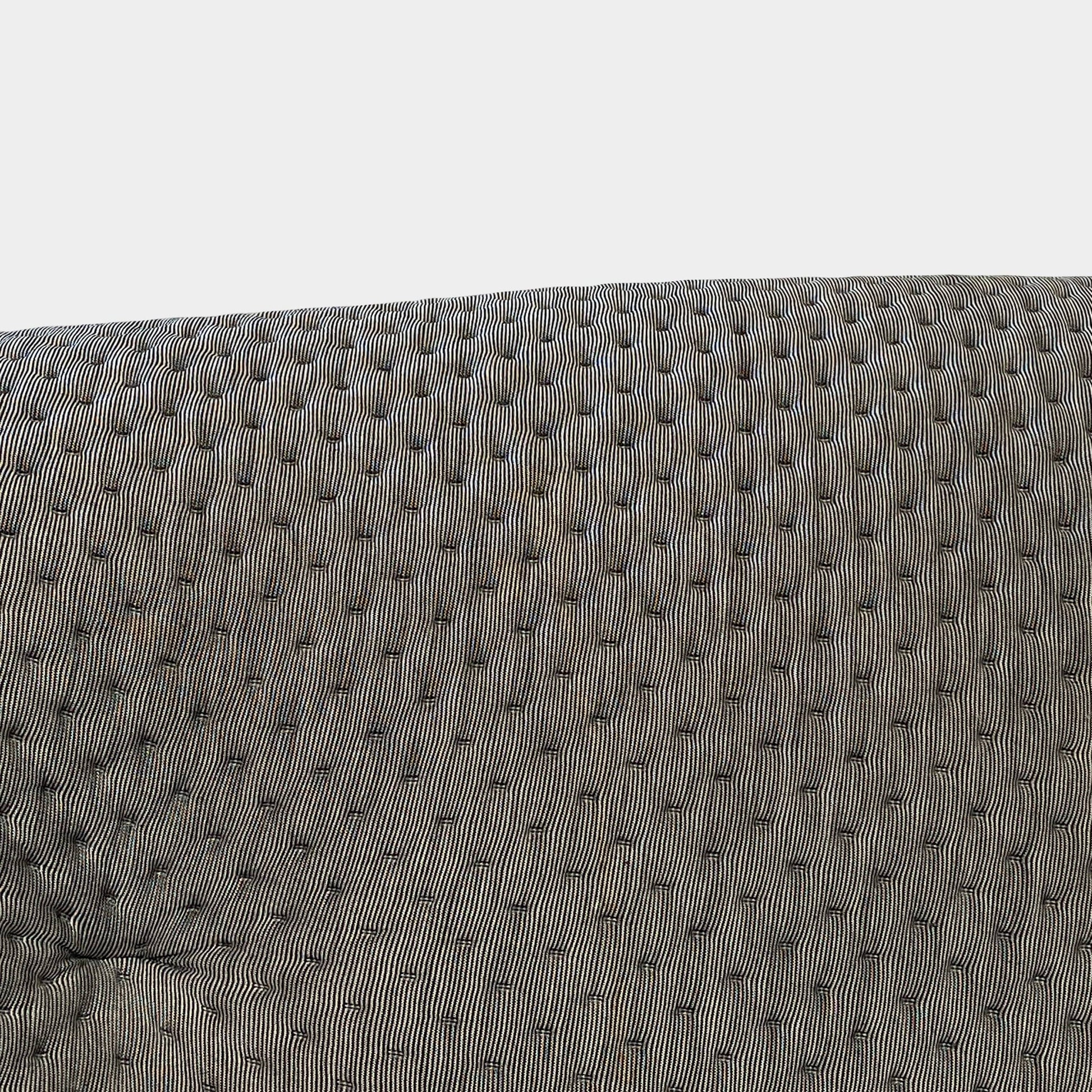 Modern tufted Ligne Roset Ploum sofa isolated against a white background.