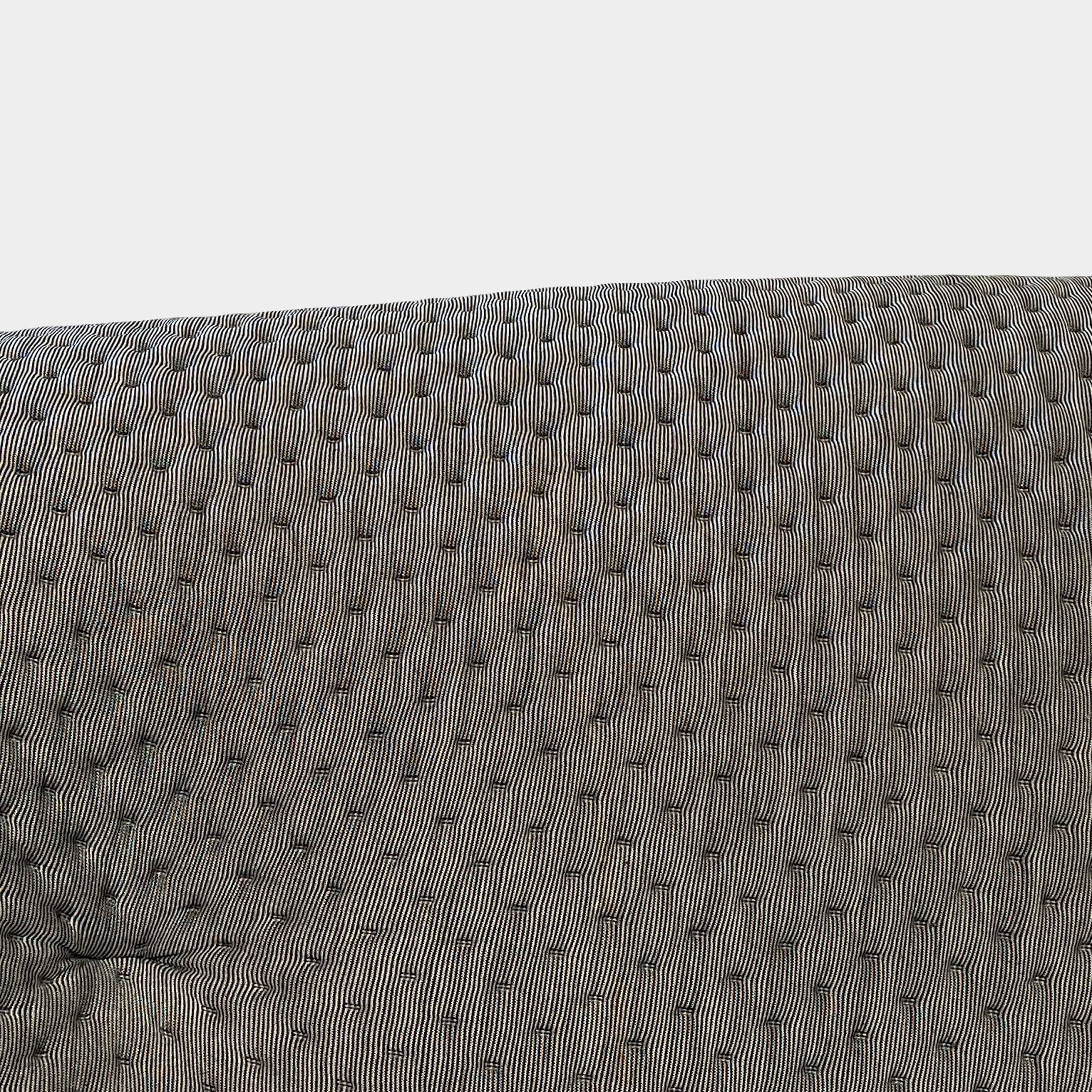 Modern tufted Ligne Roset Ploum sofa isolated against a white background.