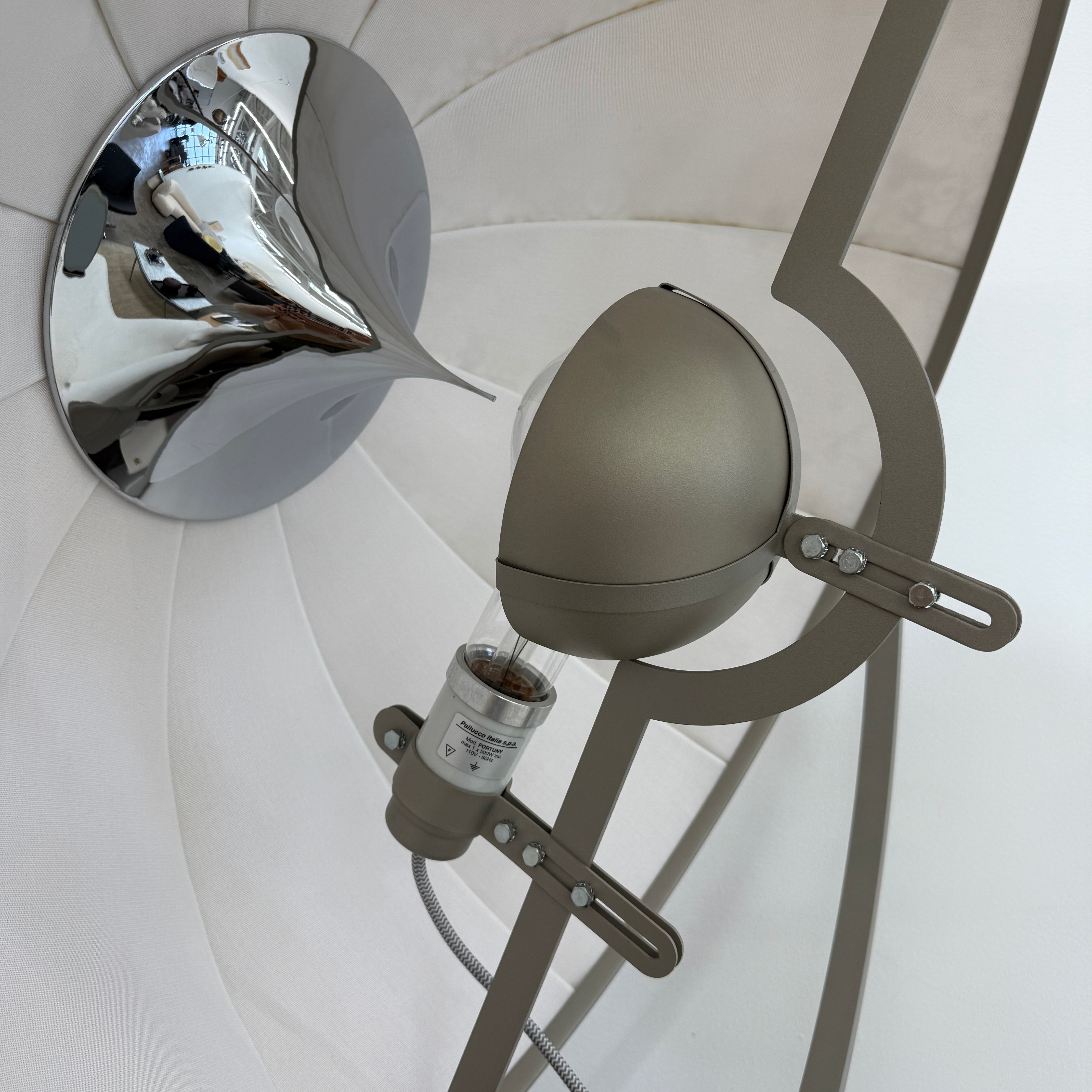 The Pallucco Italia Fortuny Ornament Floor Lamp, with its visible bulb and patterned spherical shade, gracefully stands on a plain white background, epitomizing the elegance of Pallucco Italia.