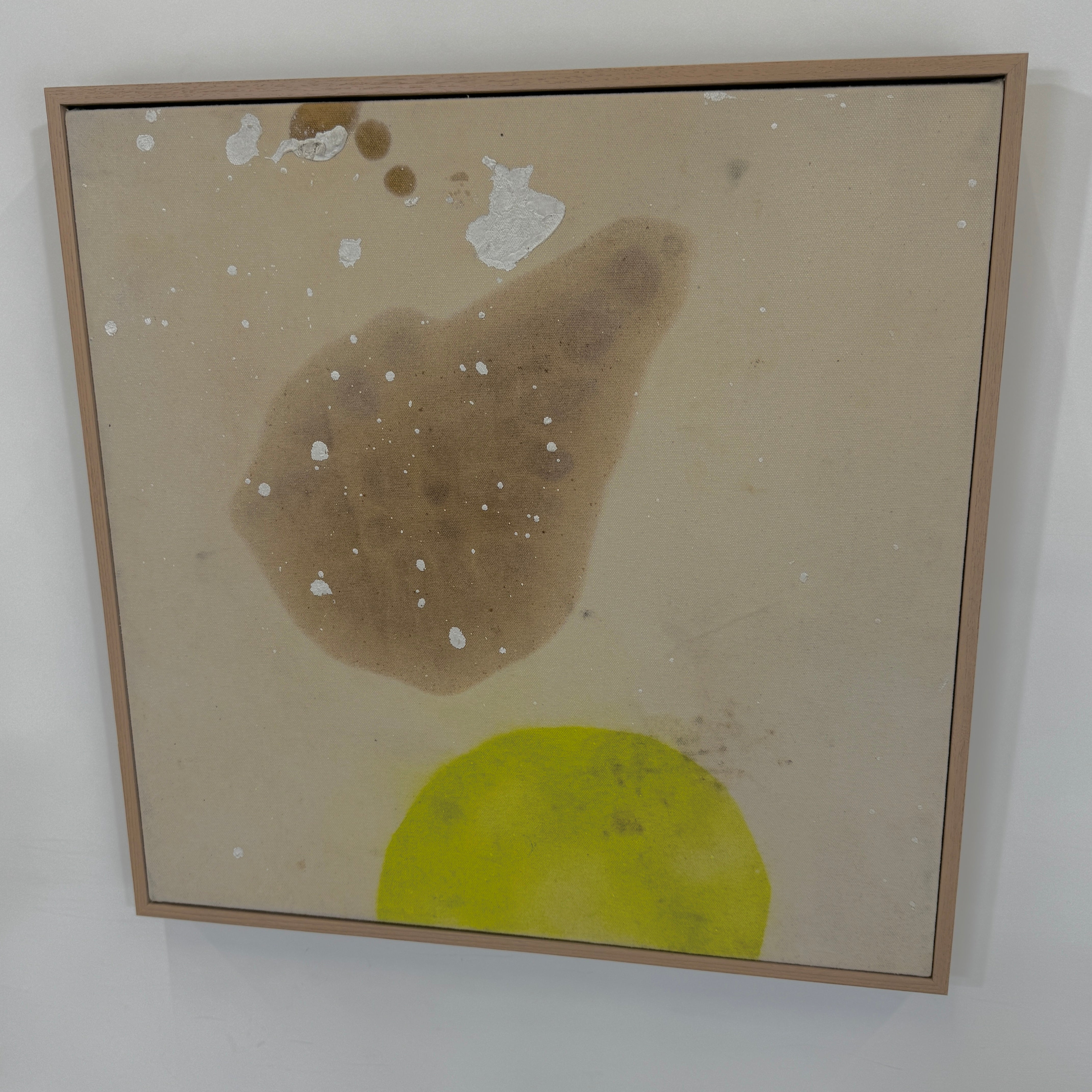 Framed Painting: Allison Caesar Mixed Media #2 - Untitled by Artist features abstract forms in brown and yellow-green with white splatters on a beige background, showcased in a thin frame.