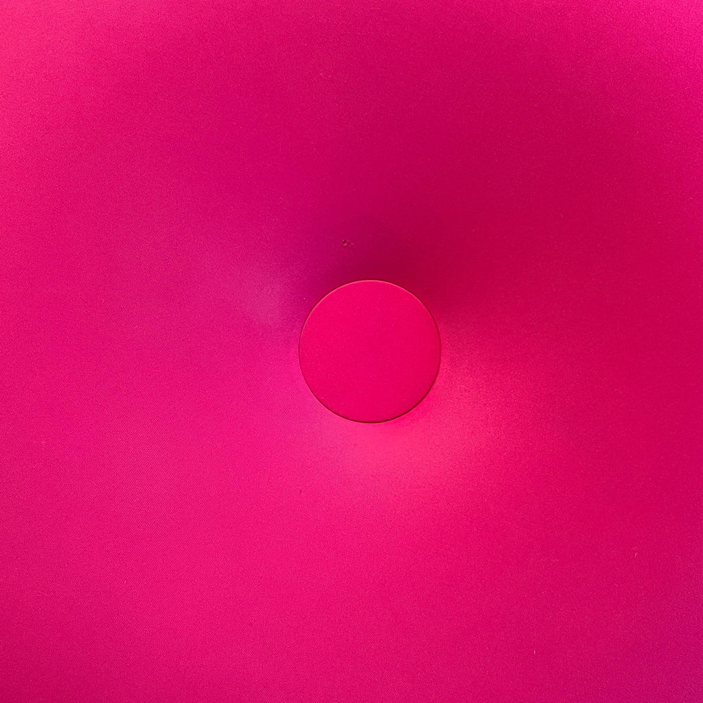 A bright pink Baleri Italia Tatone Pouf isolated on a white background.