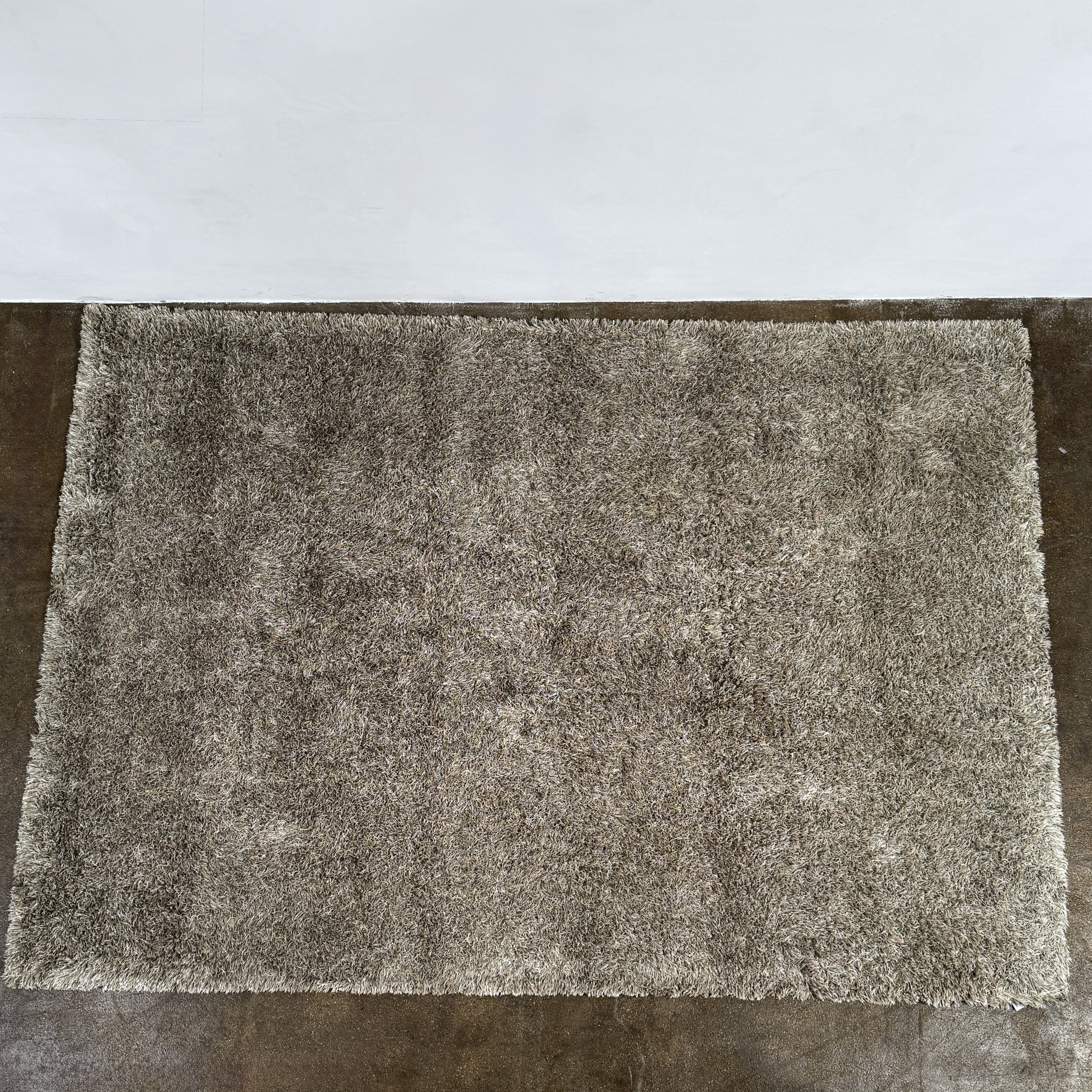 A close-up of the corner of a Kasthall Gray Fogg 2 Shag Rug (7 x 10) is shown on a white background.