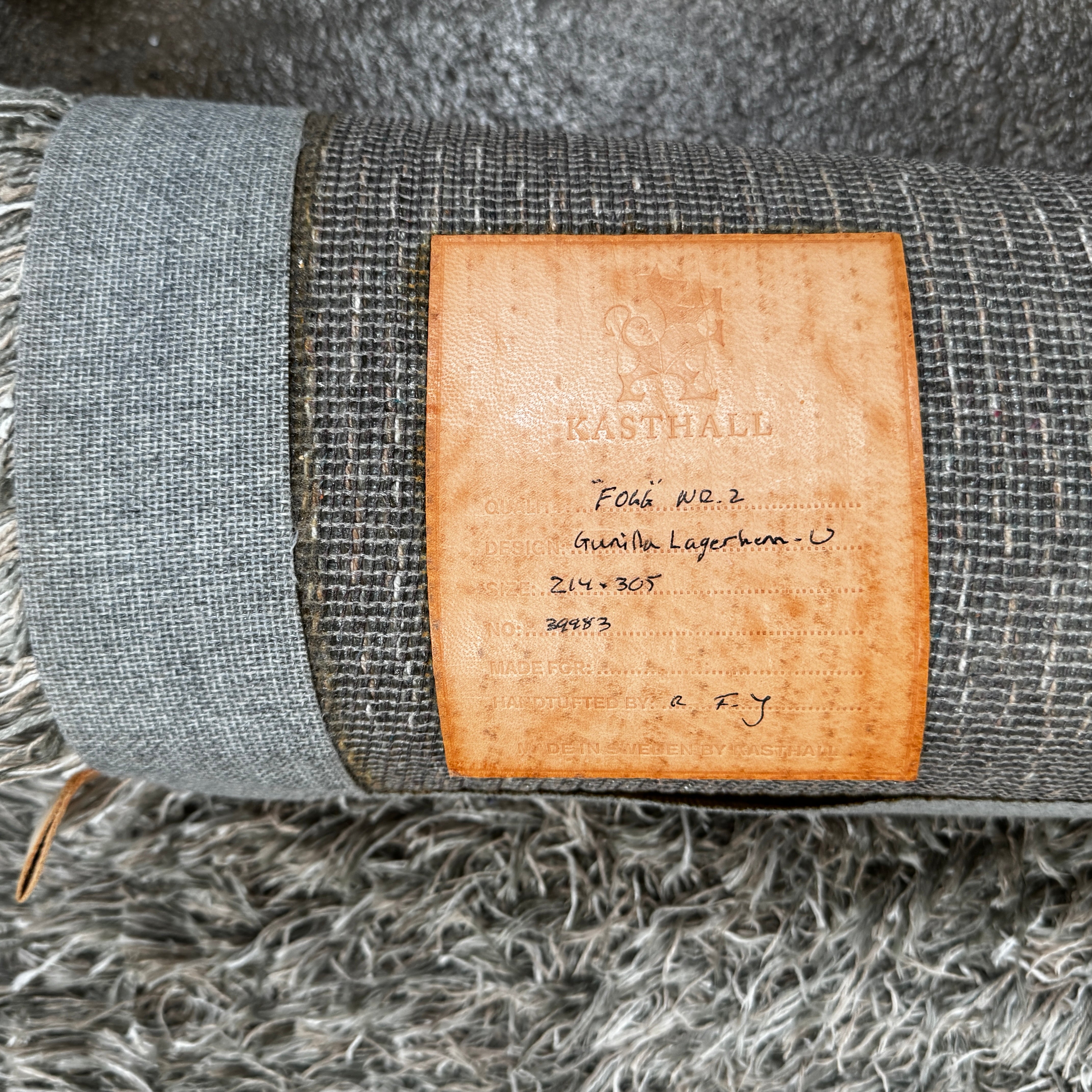 A close-up of the corner of a Kasthall Gray Fogg 2 Shag Rug (7 x 10) is shown on a white background.