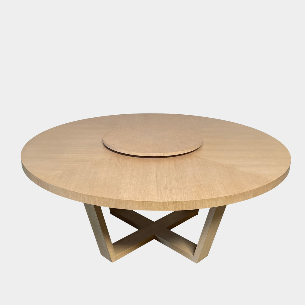 Round Maxalto Xilos dining table with rotating tray centerpiece on a crossed leg base, isolated on a white background.