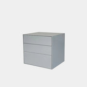 The Treku Lauki collection Side Table (2) by Treku, a gray rectangular side table with three drawers and a minimalist design, is shown against a plain white background.