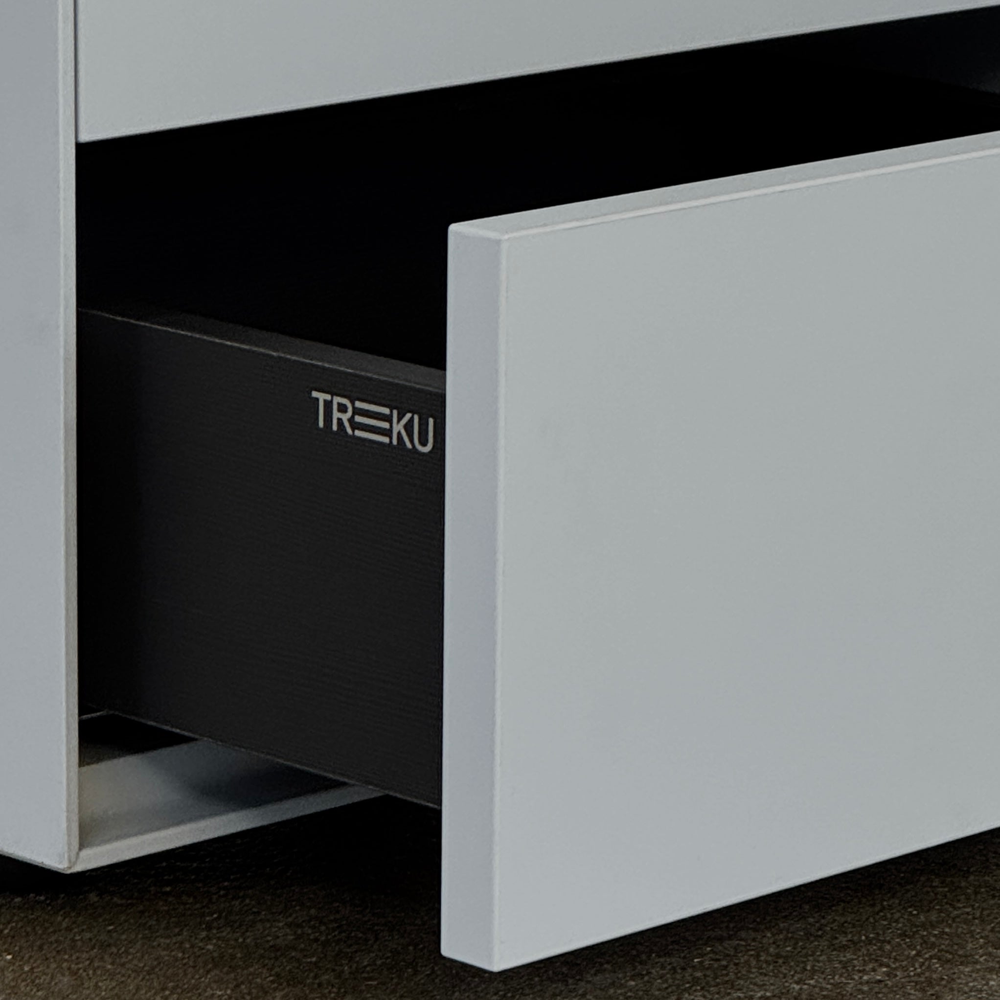 The Treku Lauki collection Side Table (2) by Treku, a gray rectangular side table with three drawers and a minimalist design, is shown against a plain white background.