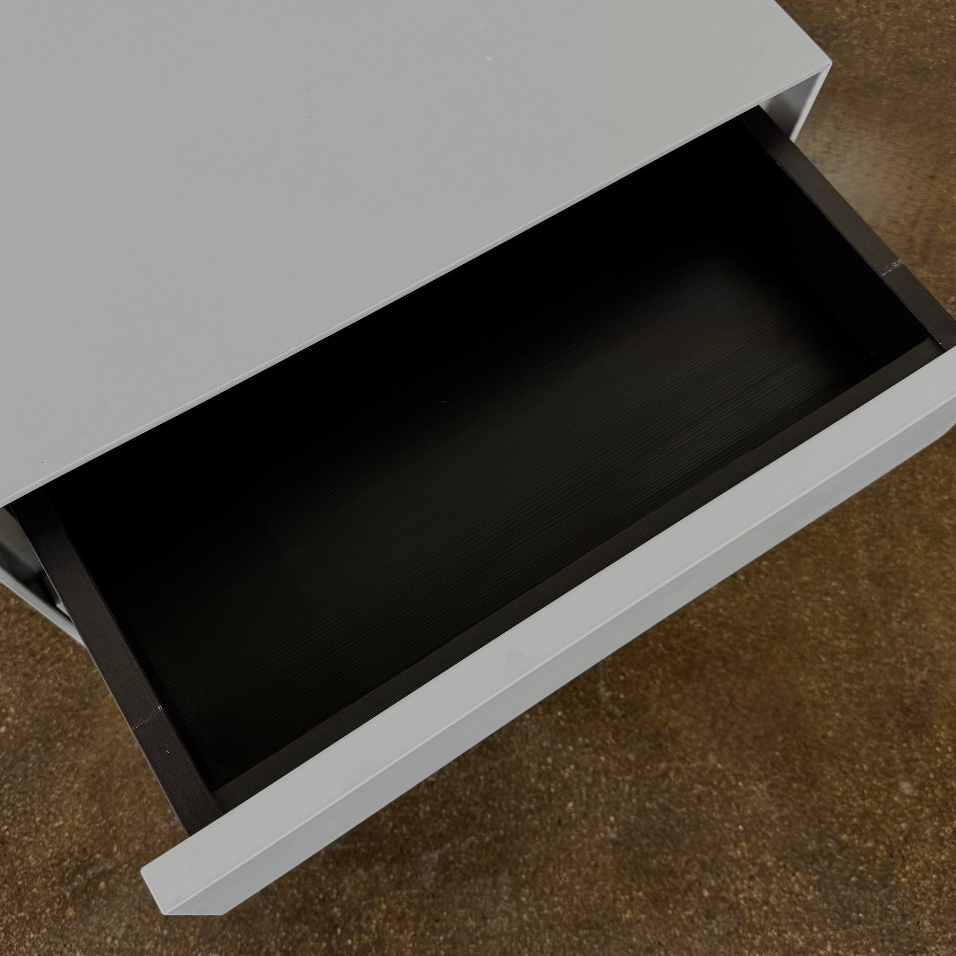 The Treku Lauki collection Side Table (2) by Treku, a gray rectangular side table with three drawers and a minimalist design, is shown against a plain white background.