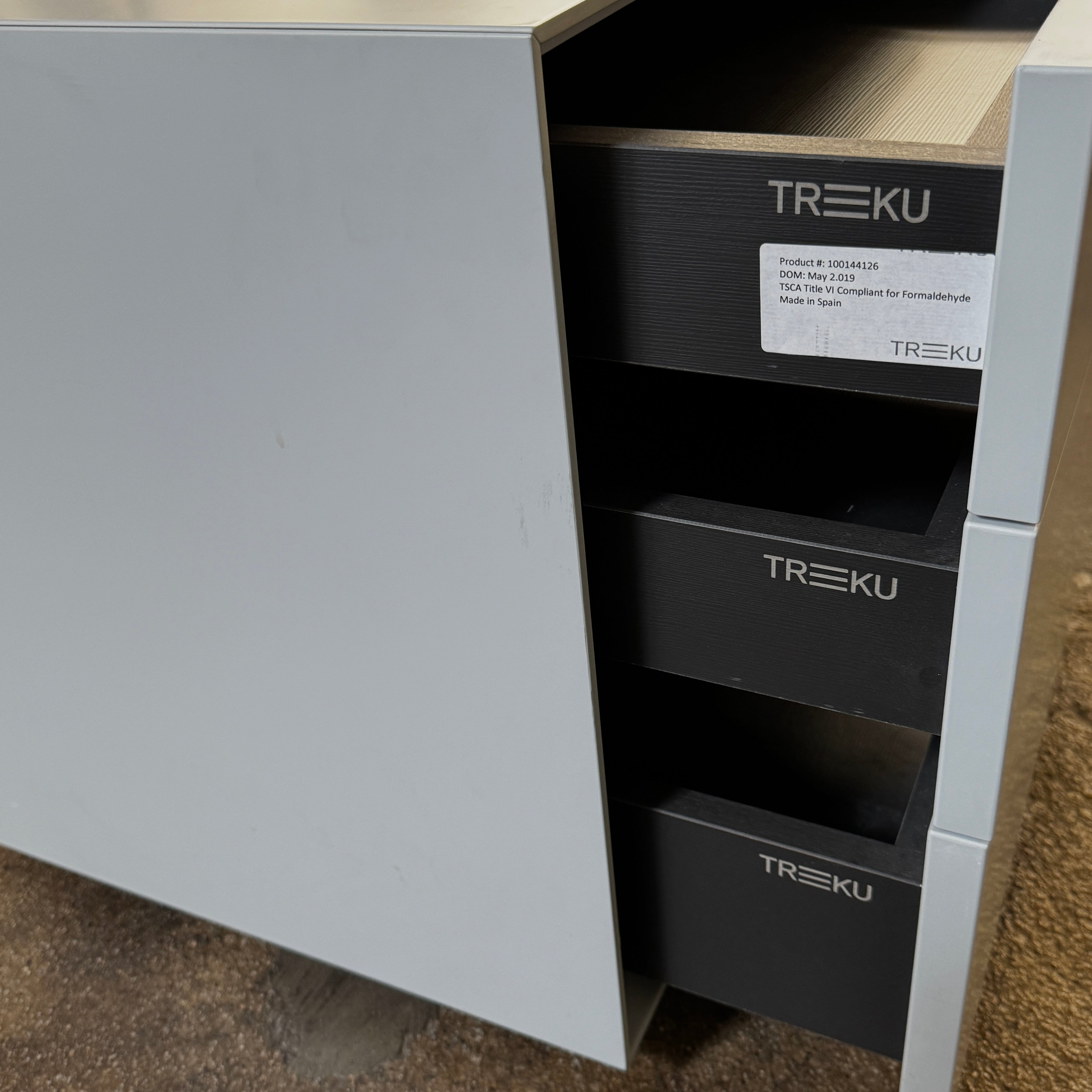 The Treku Lauki collection Side Table (2) by Treku, a gray rectangular side table with three drawers and a minimalist design, is shown against a plain white background.