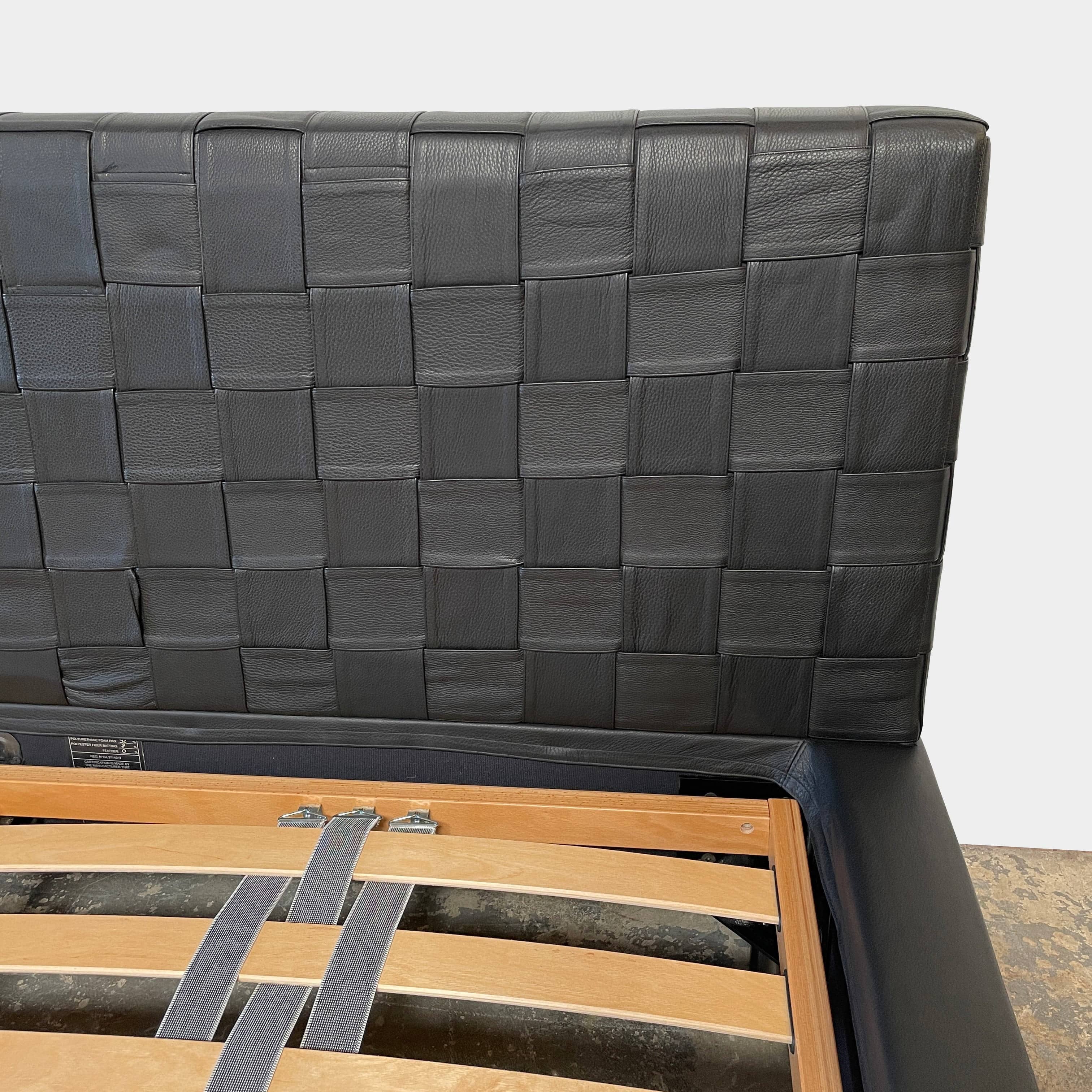 A Minotti Bartlett Cal King Bed with a wooden slatted base.