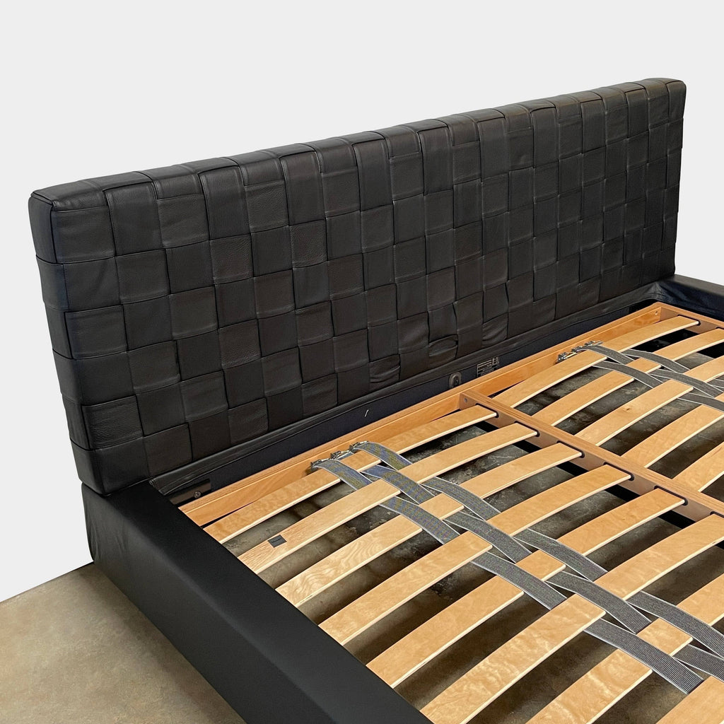 A Minotti Bartlett Cal King Bed with a wooden slatted base.