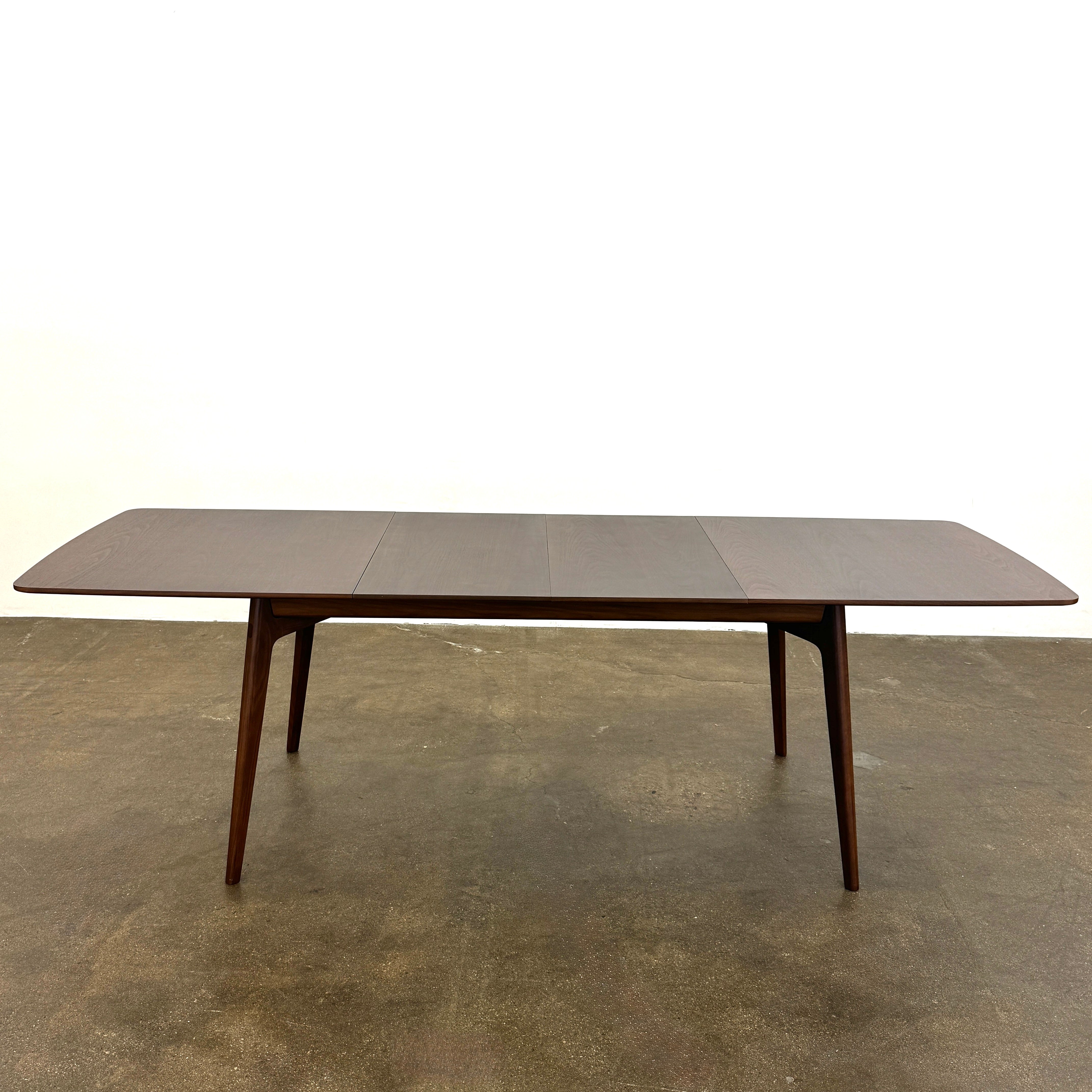 The Case Design Dulwich Extension Table by Case is an elegant rectangular walnut dining table with four legs and a smooth, flat surface, viewed from the front against a plain white background—ideal for modern dining spaces.