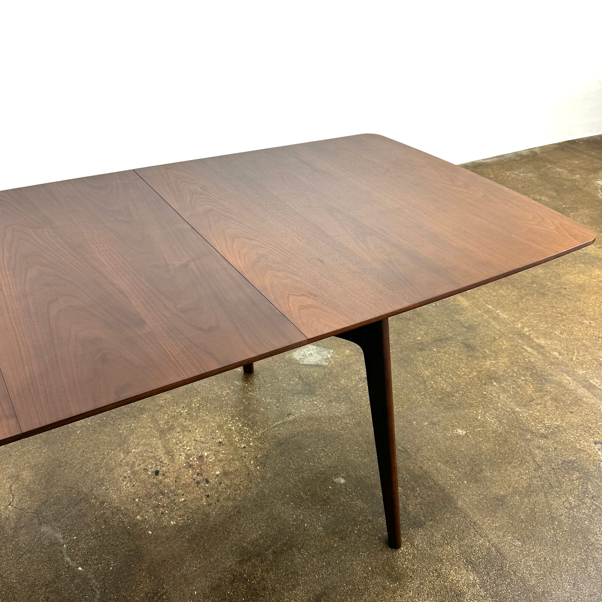 The Case Design Dulwich Extension Table by Case is an elegant rectangular walnut dining table with four legs and a smooth, flat surface, viewed from the front against a plain white background—ideal for modern dining spaces.